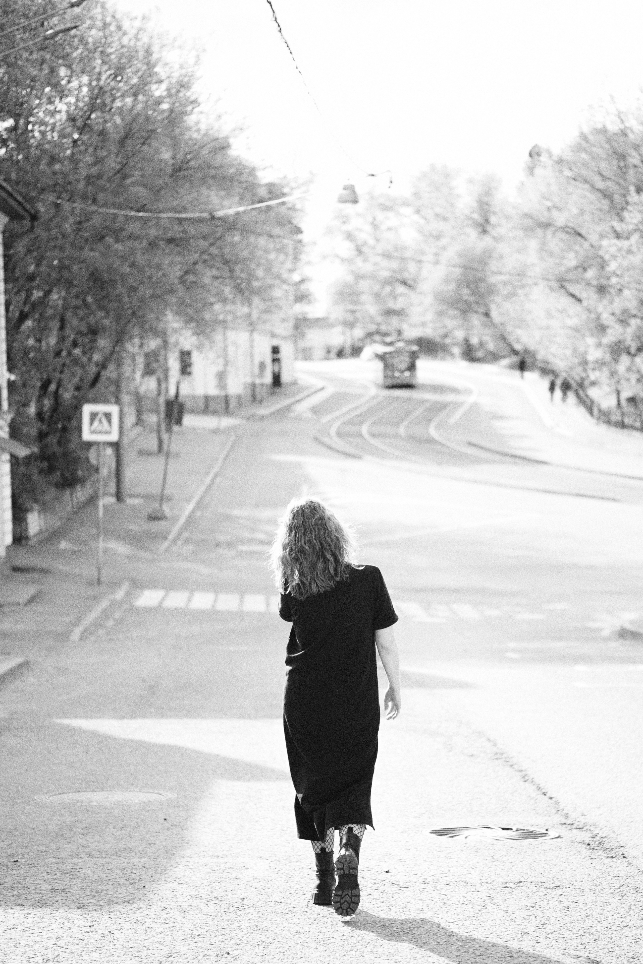 Женщина идет по улице, залитой солнцем