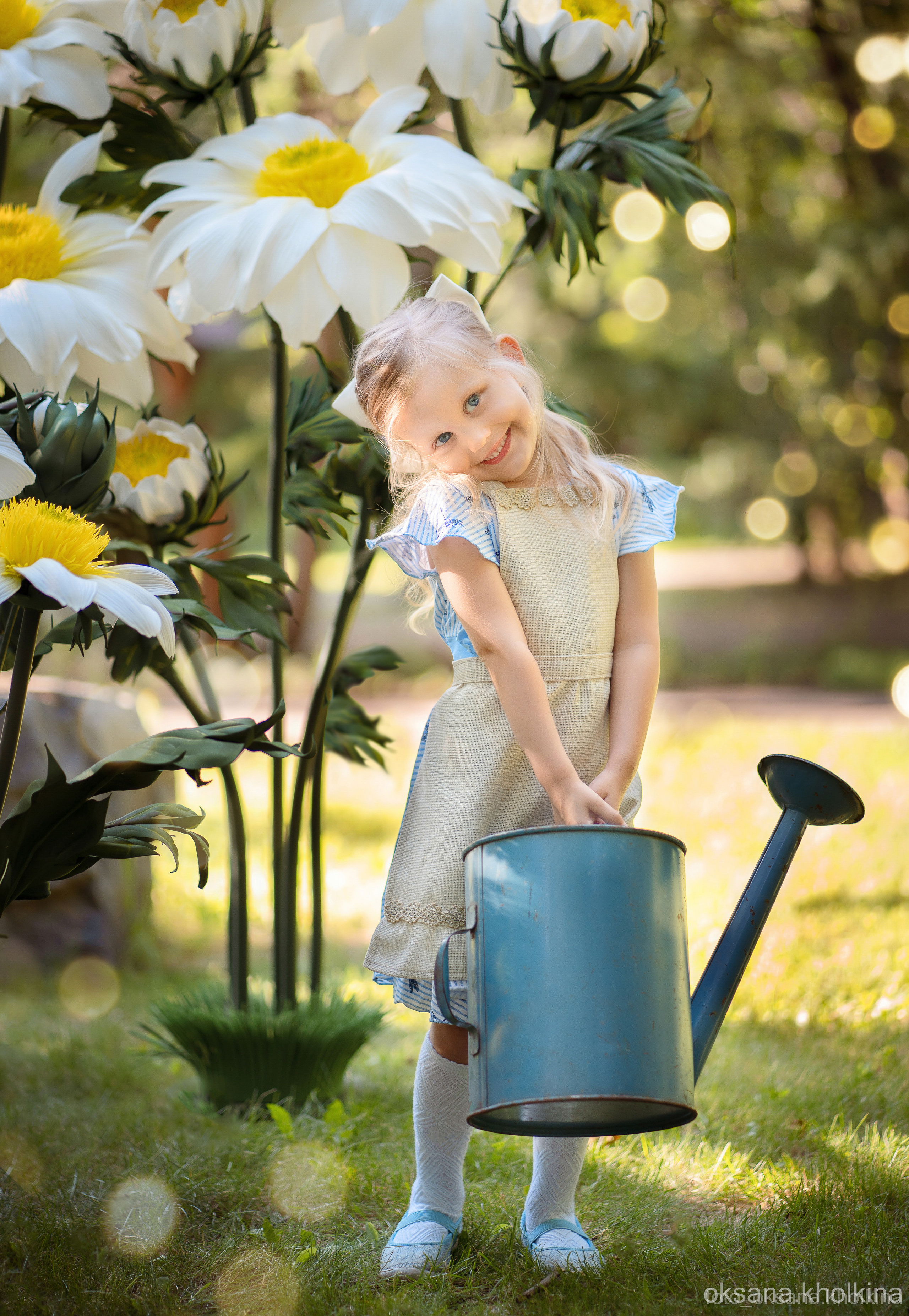 Детская фотосессия на улице. Девочка с лейкой и ромашками.