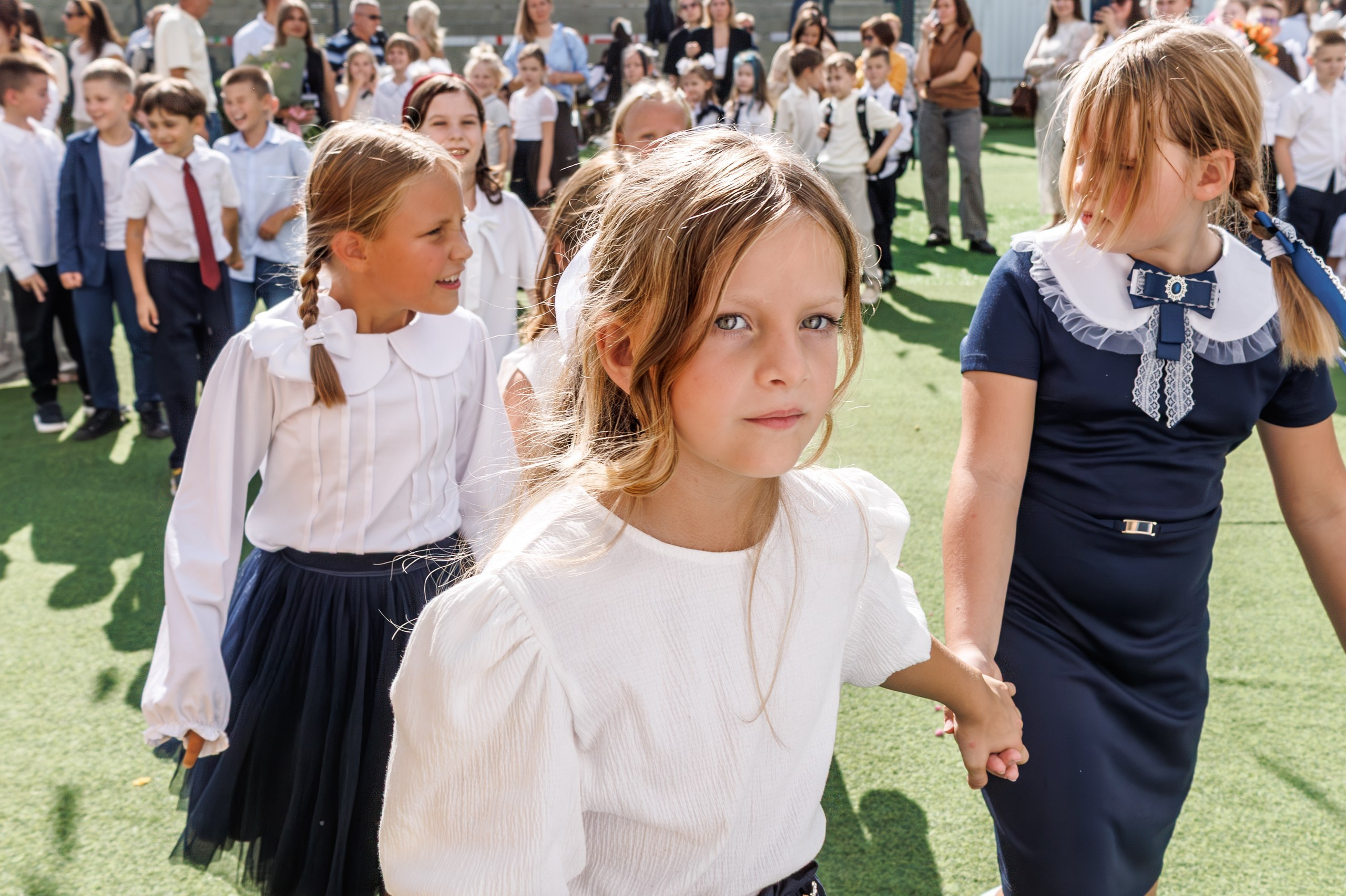 Линейка 1 сентября в школе - дети с букетами, радостные родители и учителя