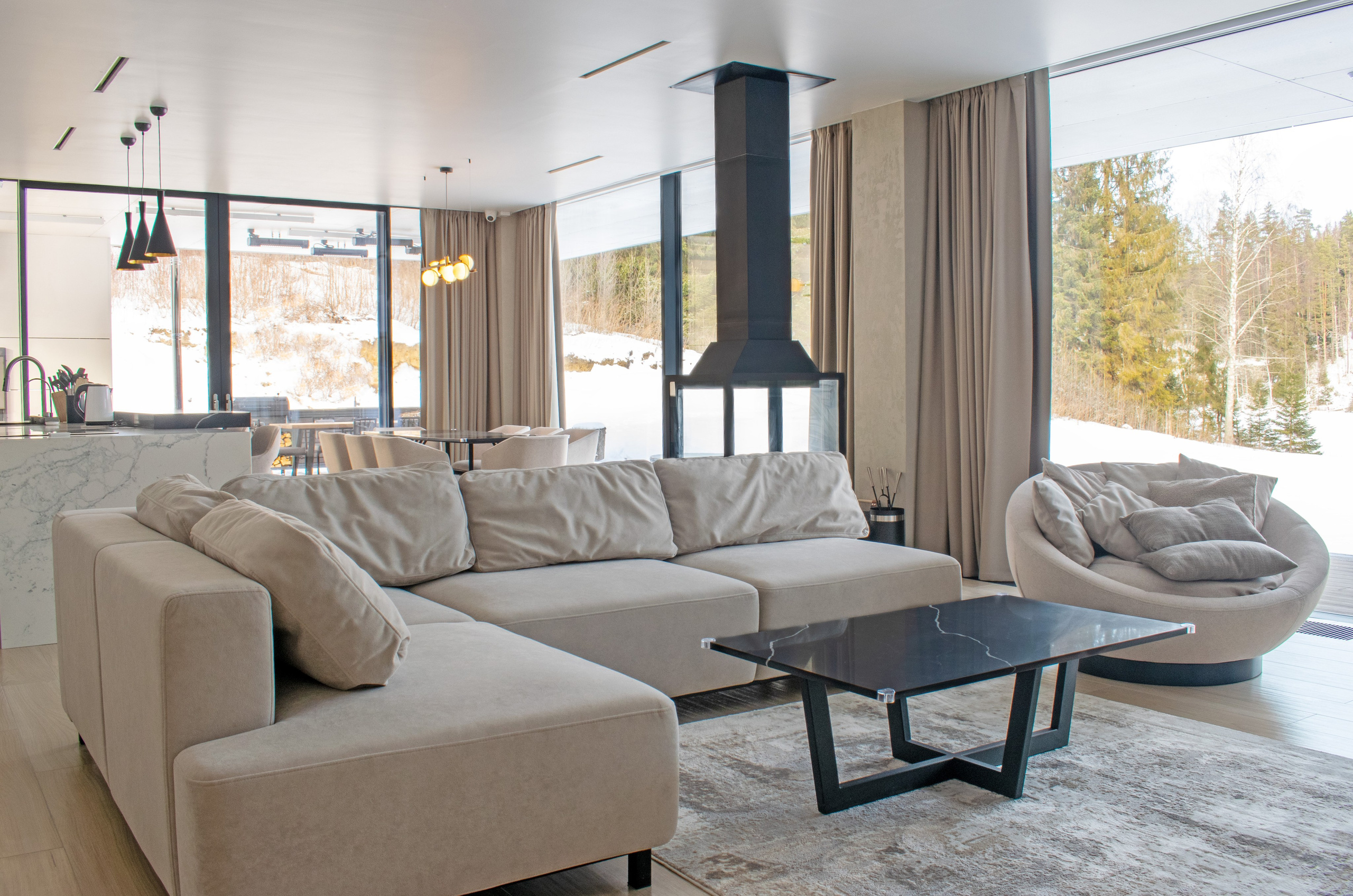 Интерьер элитного гостевого дома для сдачи в аренду в Карелии в Сортавальском районе. Фотосъемка зоны отдыха: диван, журнальный столик и камин.