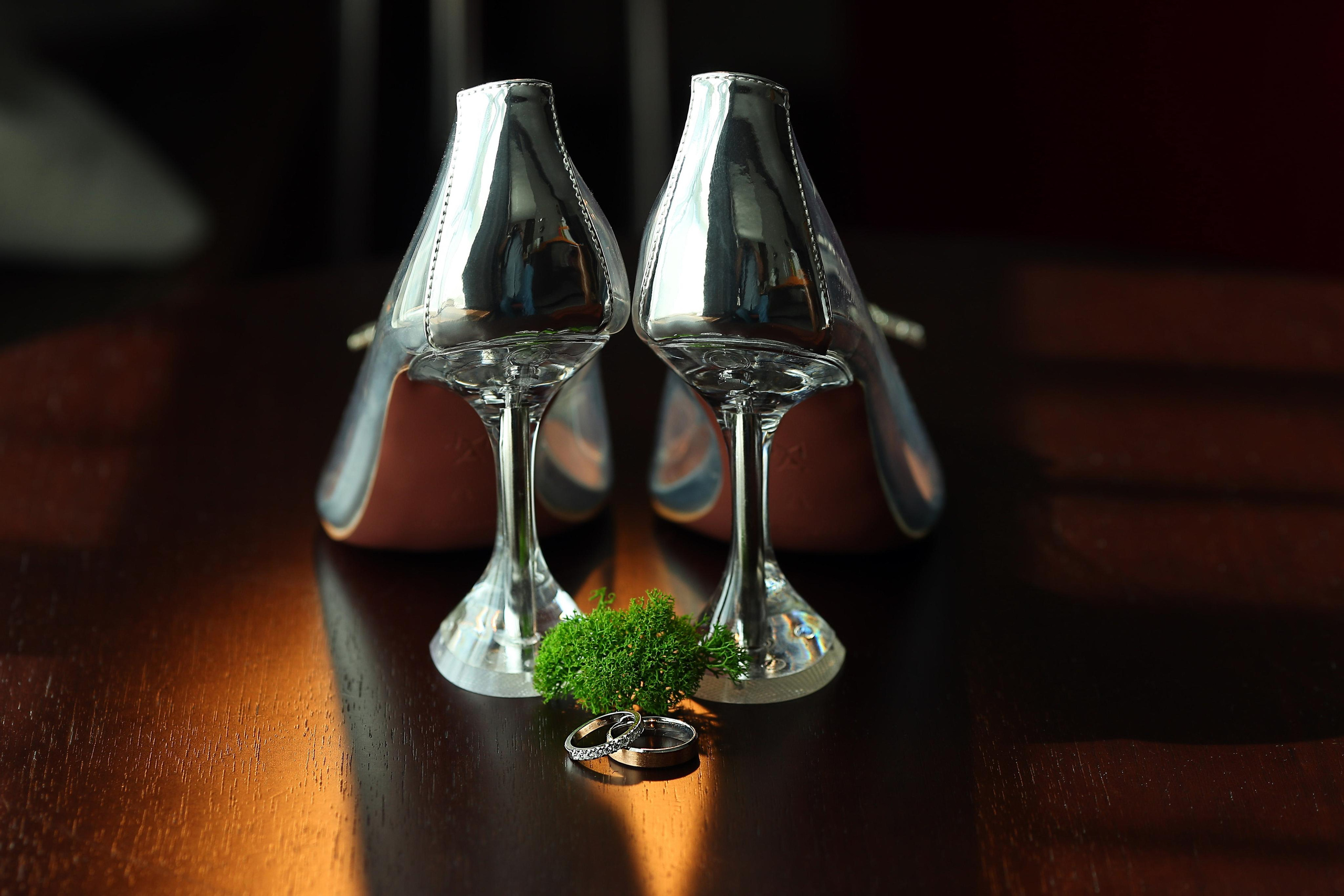 Свадебные туфли в виде бокалов стоят на столе.