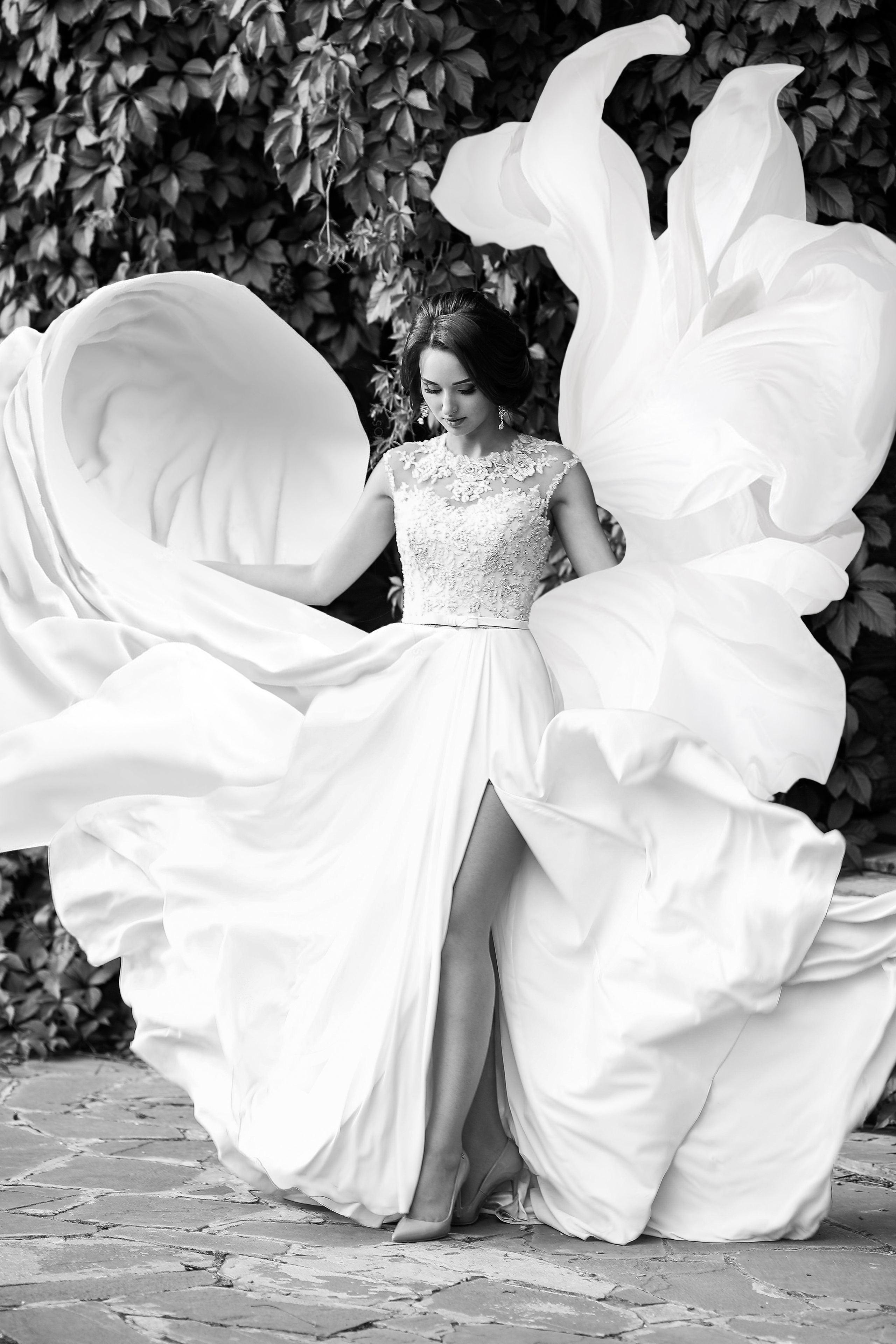 Белое платье в виде цветка развивается на ветру.