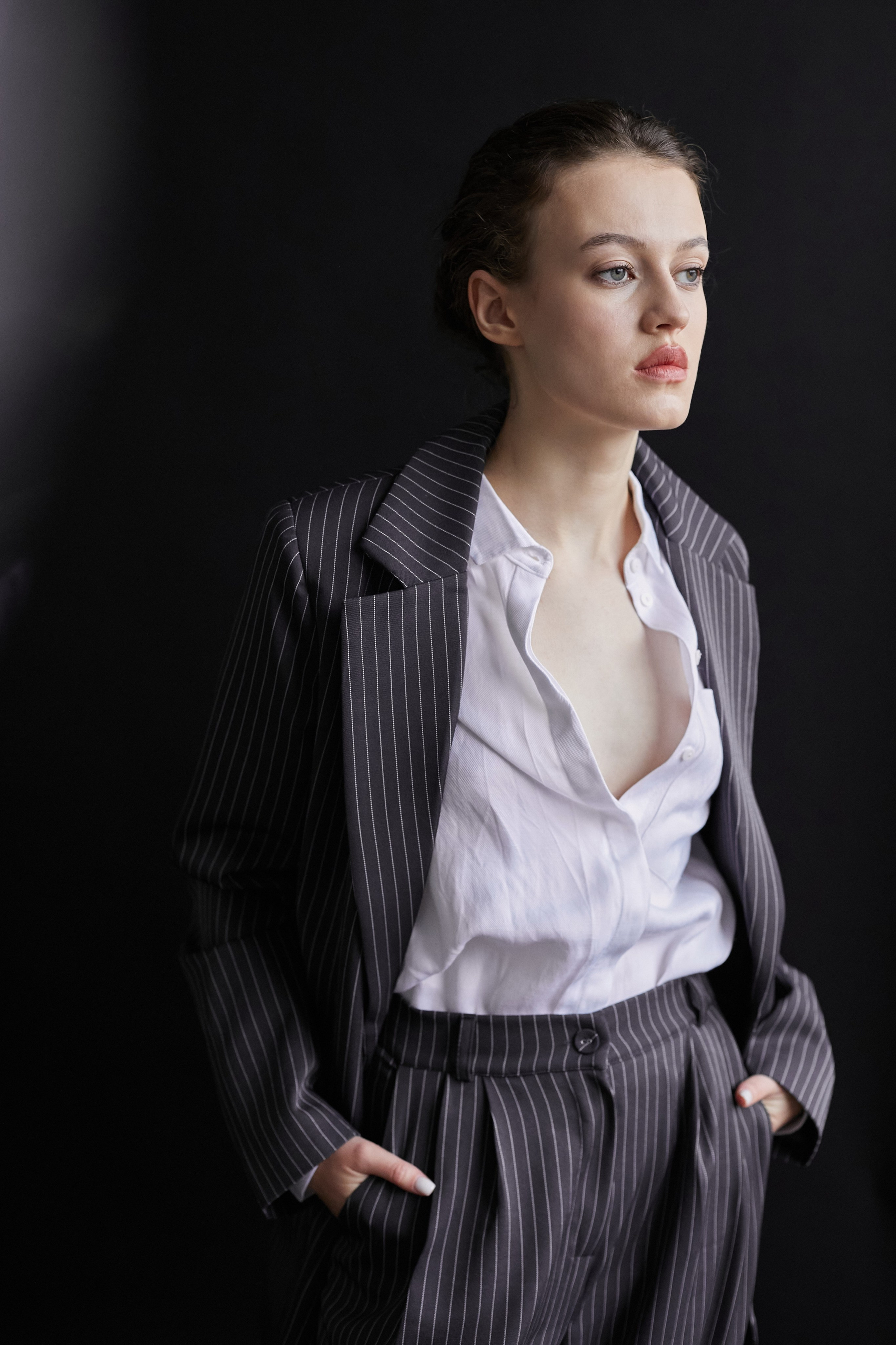 Фотограф в Москве. Студия. Студийный портрет. Девушка в пиджаке. Девушка на стуле на черном фоне. Красивая девушка в мужском костюме. Женский портрет.