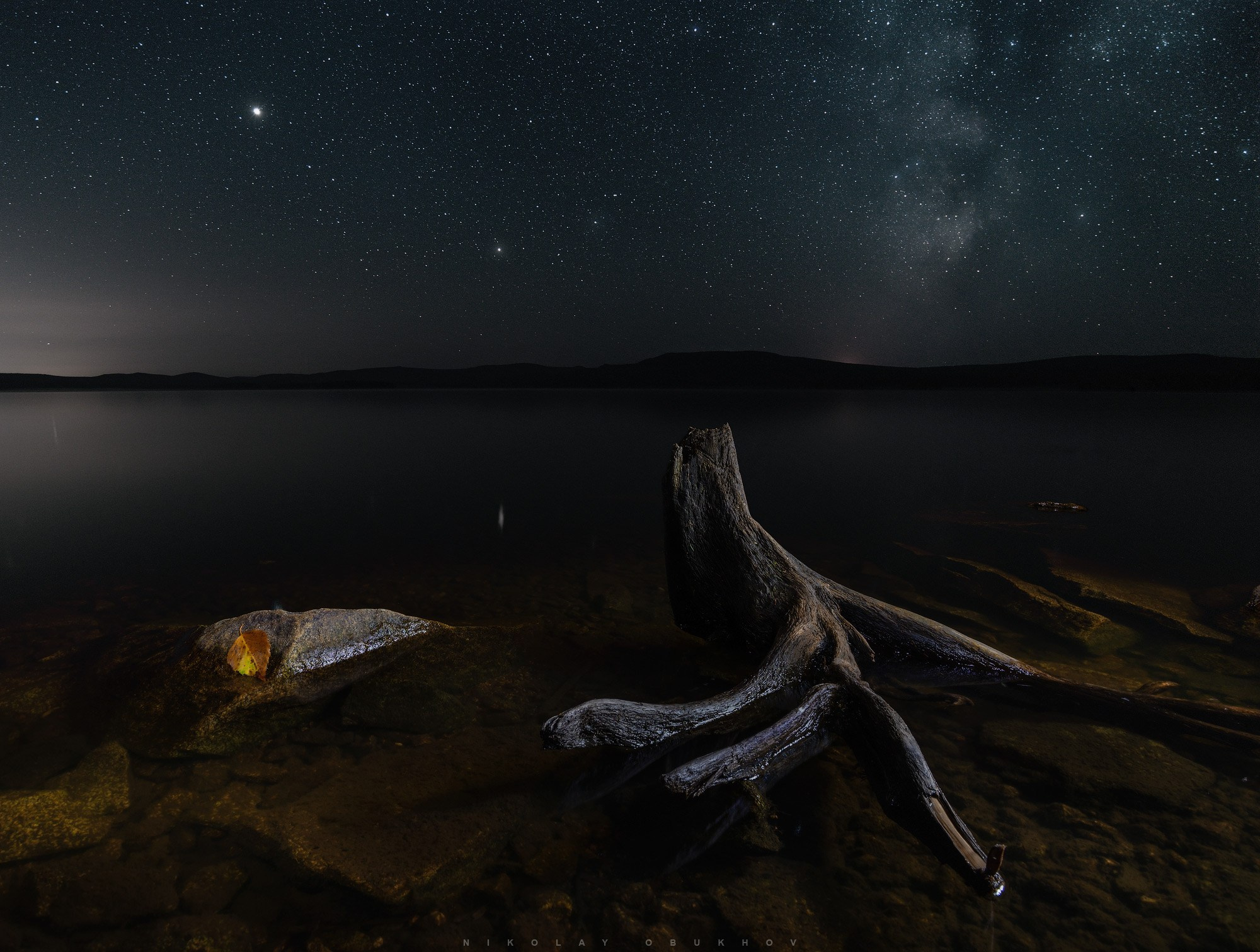 Красивый ночной пейзаж Среднего Урала: звёзды, пруд и коряга у Черноисточинска под сиянием Млечного Пути.