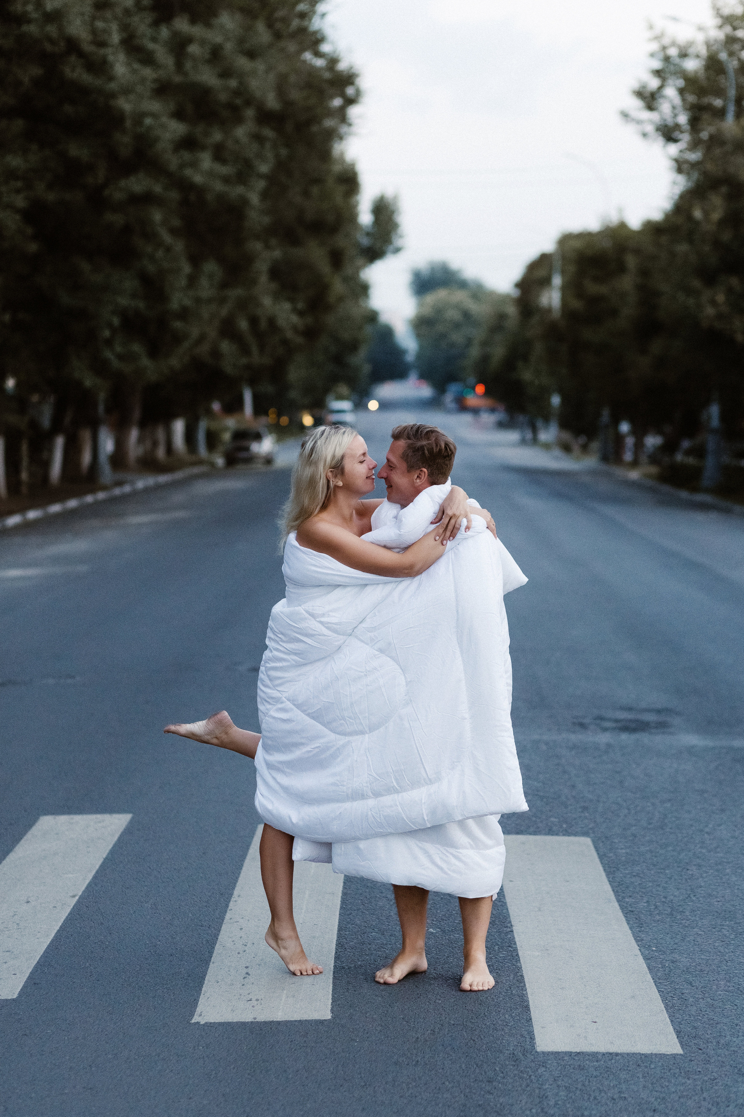 Пара в белых одеялах на рассвете на улице Петровская возле Театра Чехова в Таганроге