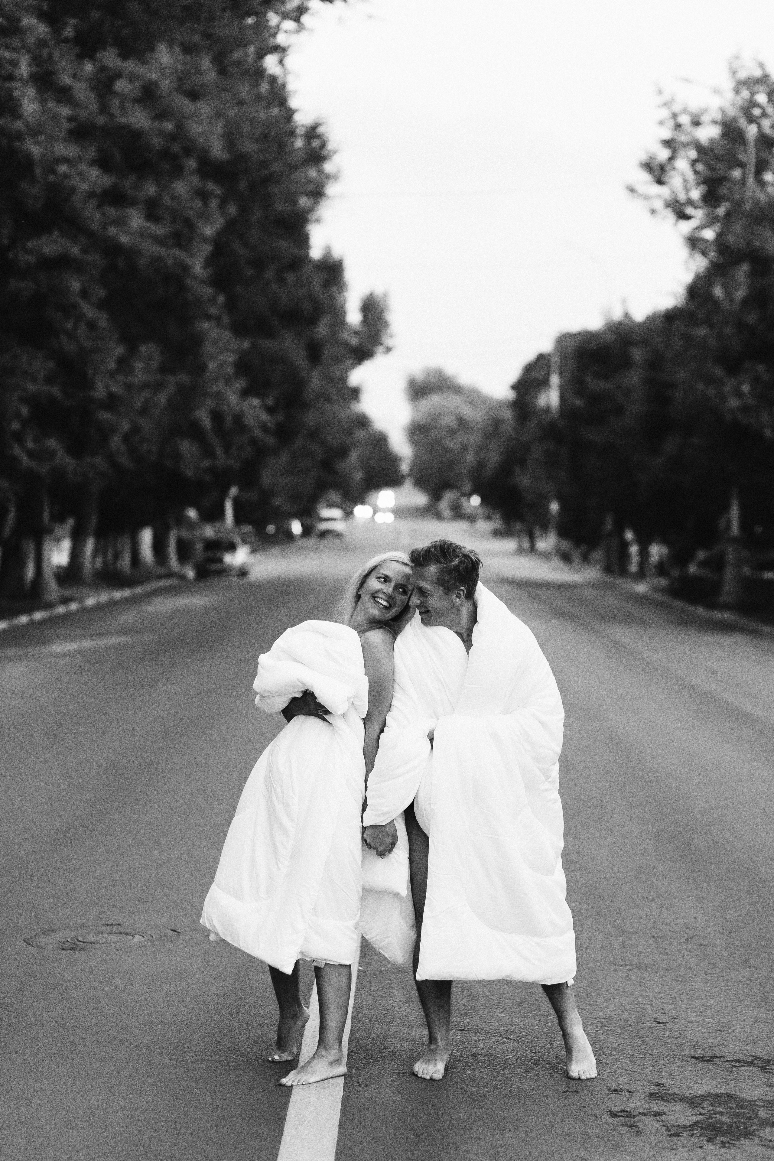 Счастливая пара в одеялах на пустынной улице Петровская возле Театра Чехова в Таганроге