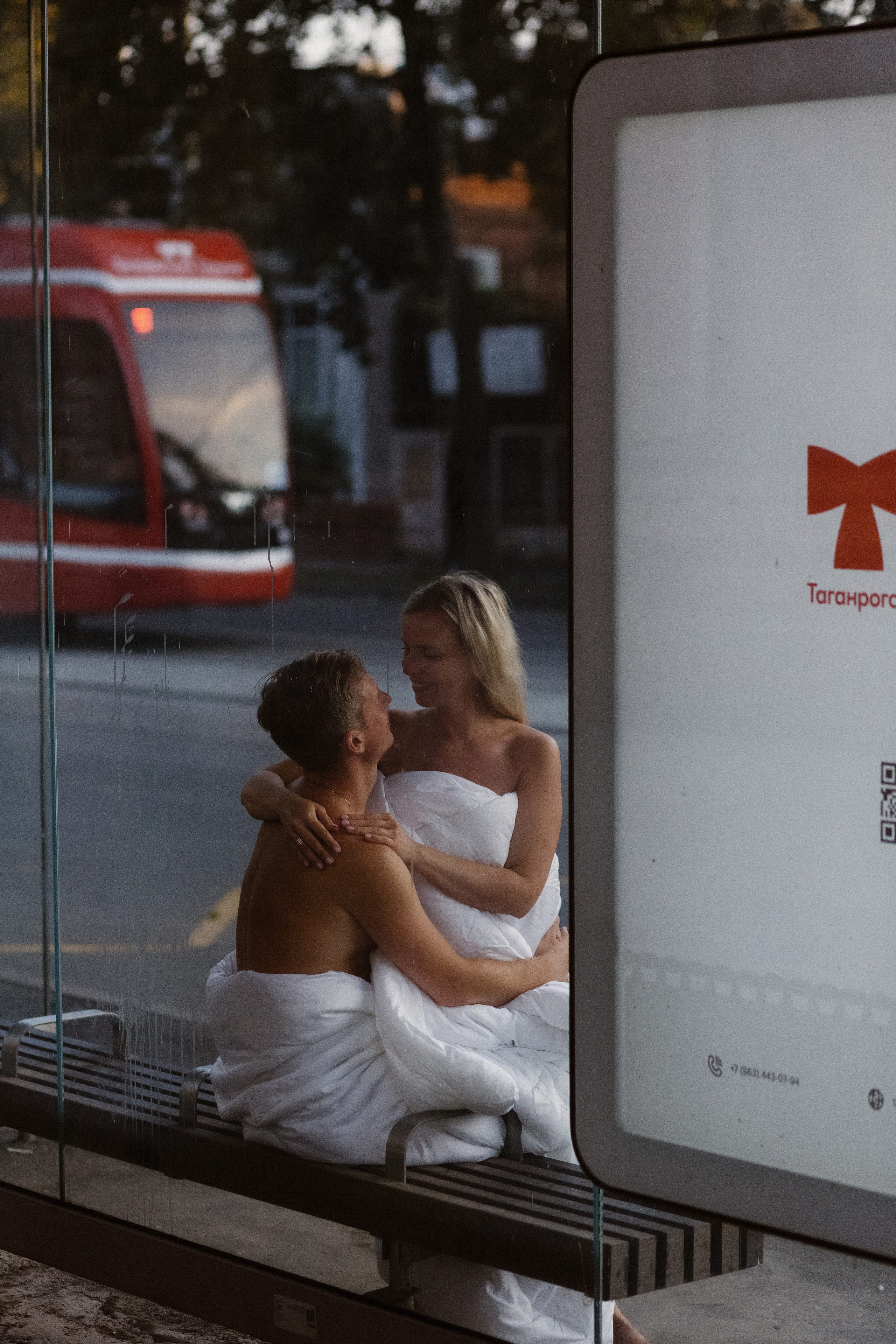 Романтическая пара в белых одеялах наслаждается утром у остановки Таганрогского трамвая на улице Фрунзе