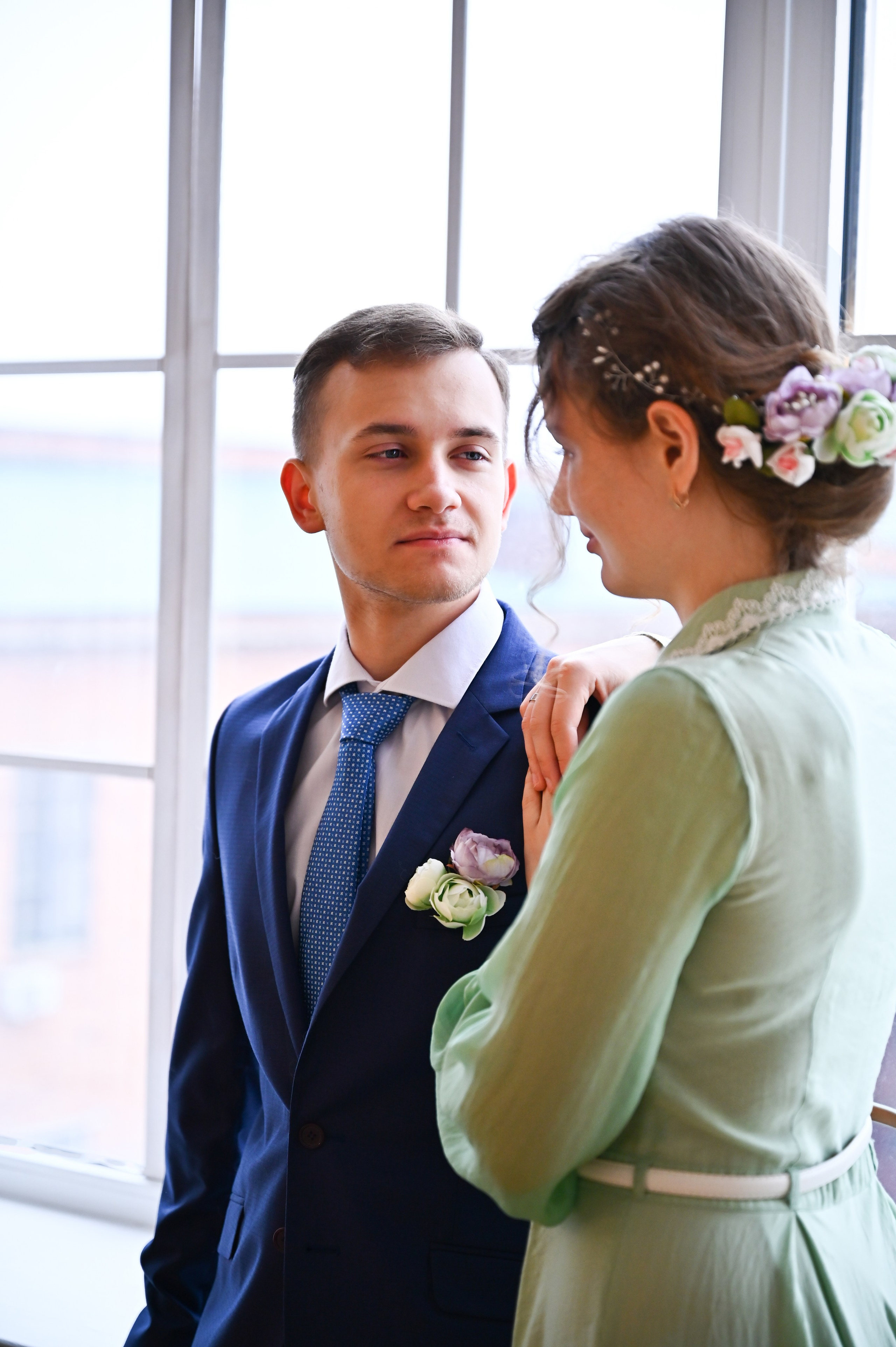 Студийная съемка жениха и невесты в светлых тонах на фоне окна