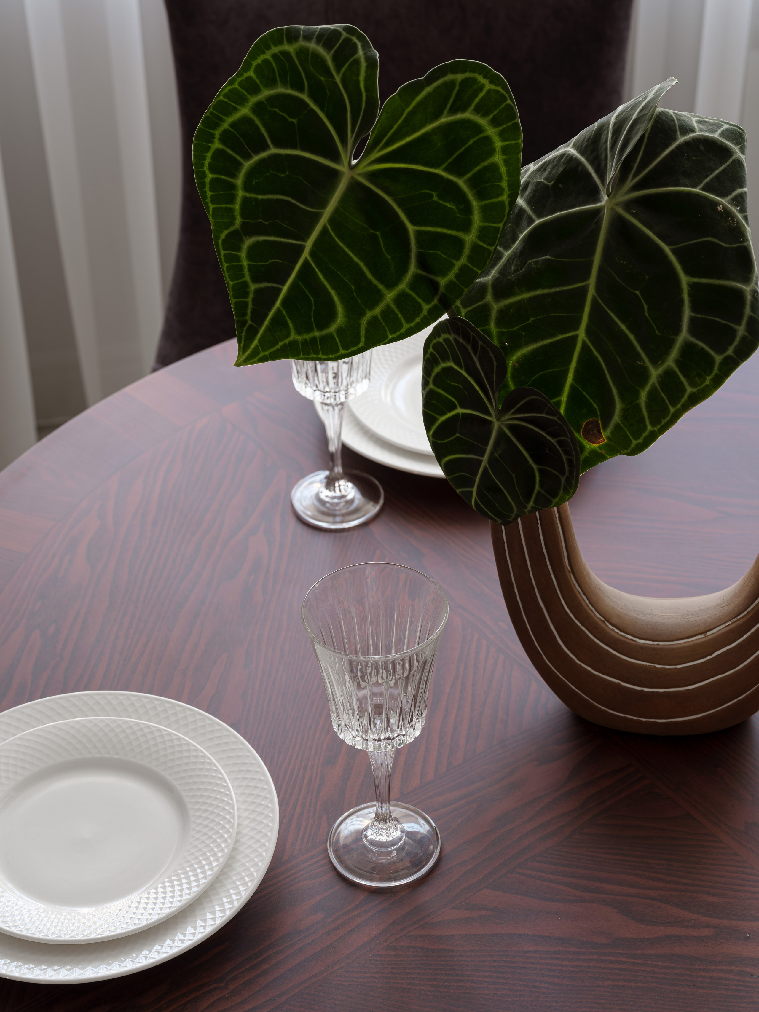 Фото современного интерьера кухни-столовой, крупный план сервировки с белыми тарелками, бокалами и декоративной вазой с зелеными листьями. Проект дизайнера Татьяны Диденко, съемка Сергея Денисенко, стилизация Натальи Якушевой.