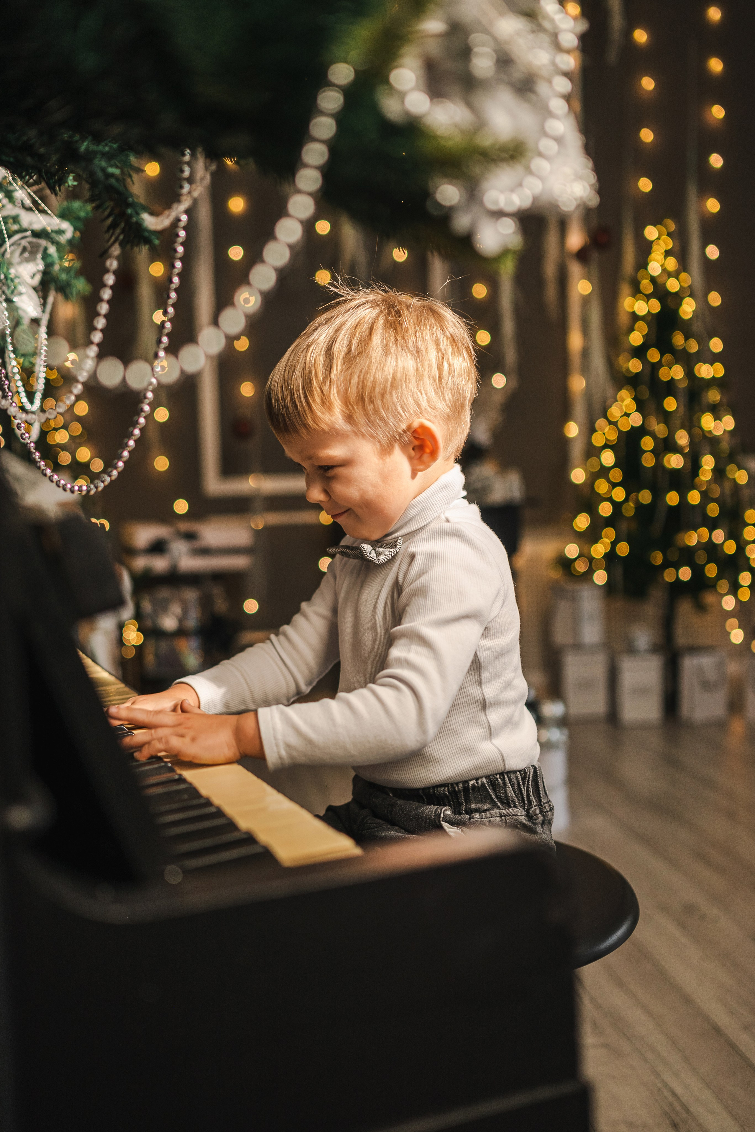 Детская семейная новогодняя фотосессия 2025 в фотостудии в Каменске-Шахтинском и Ростове-на-Дону. Ребенок играет на пианино. Фотограф Ольга Сагал 
