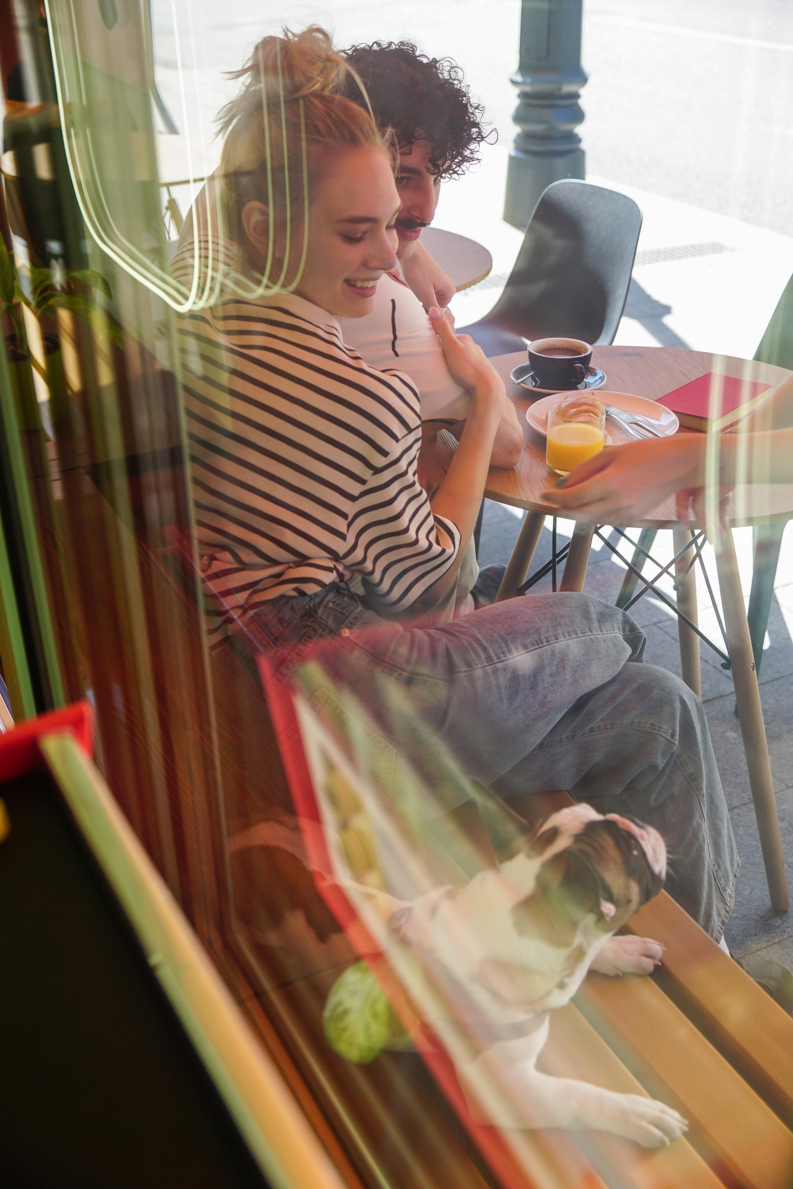 Девушка и мужчина сидят за столиком в кафе