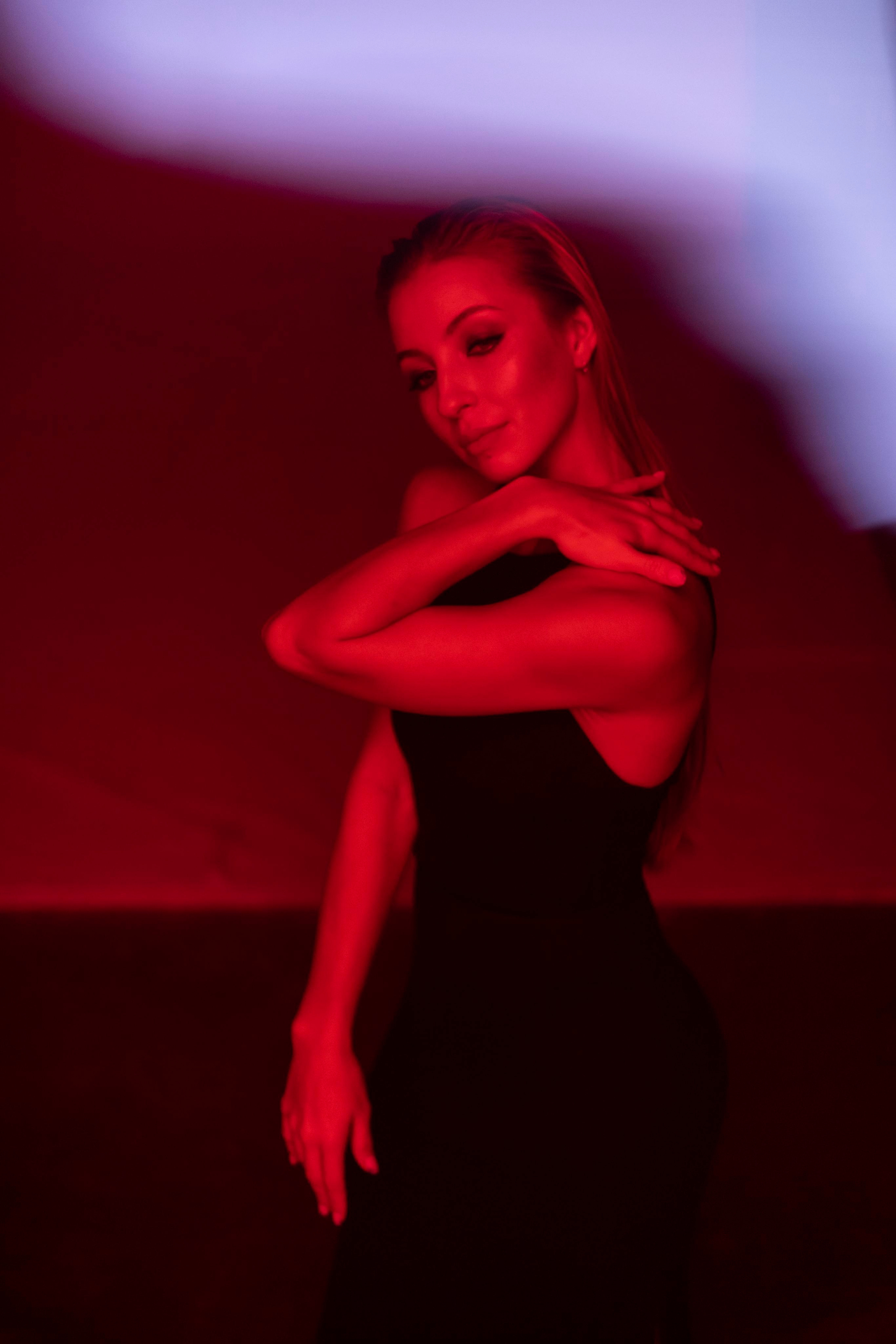 Красивая девушка Софья Горбунова в красном свете с загнутой рукой. Фотосессия в студии