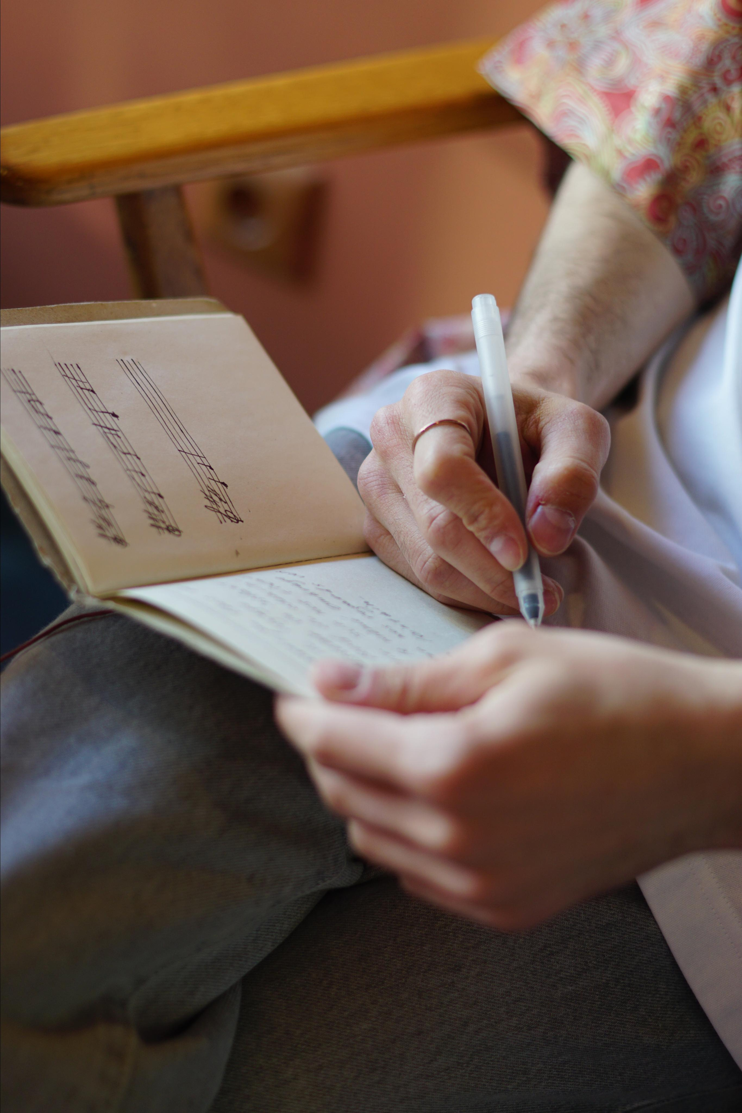 Человек что-то записывает в тетрадь