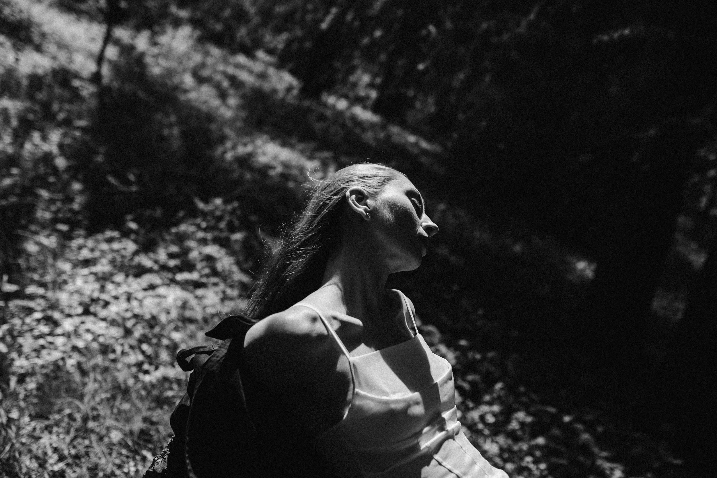 Девушка в голыми плечами лежит на солнечной поляне