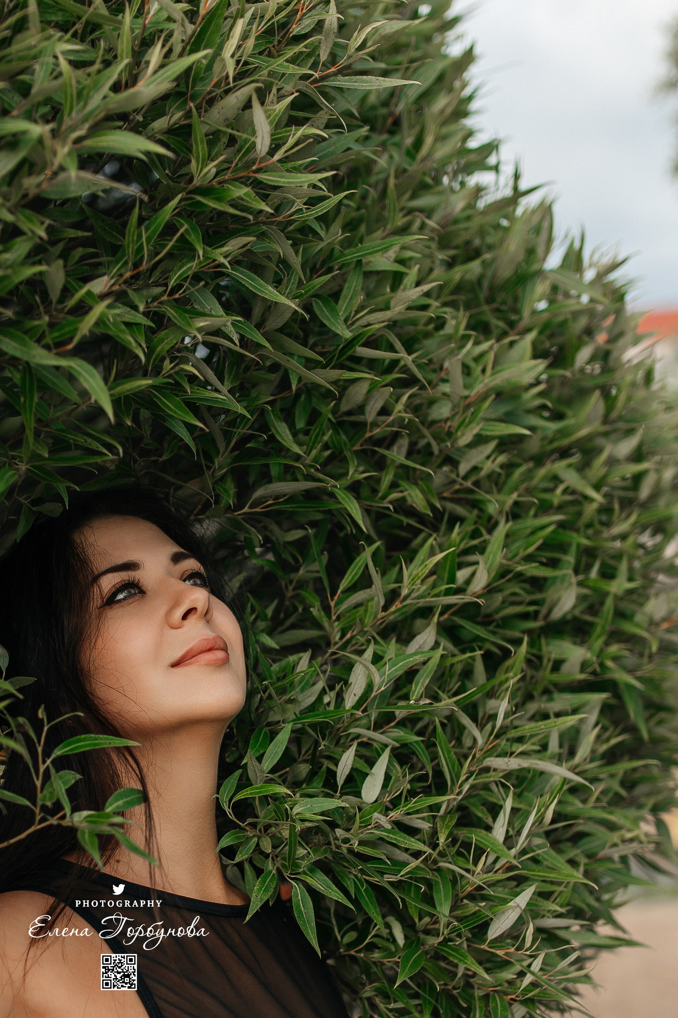 Девушка фотографирутся в листьях ивы