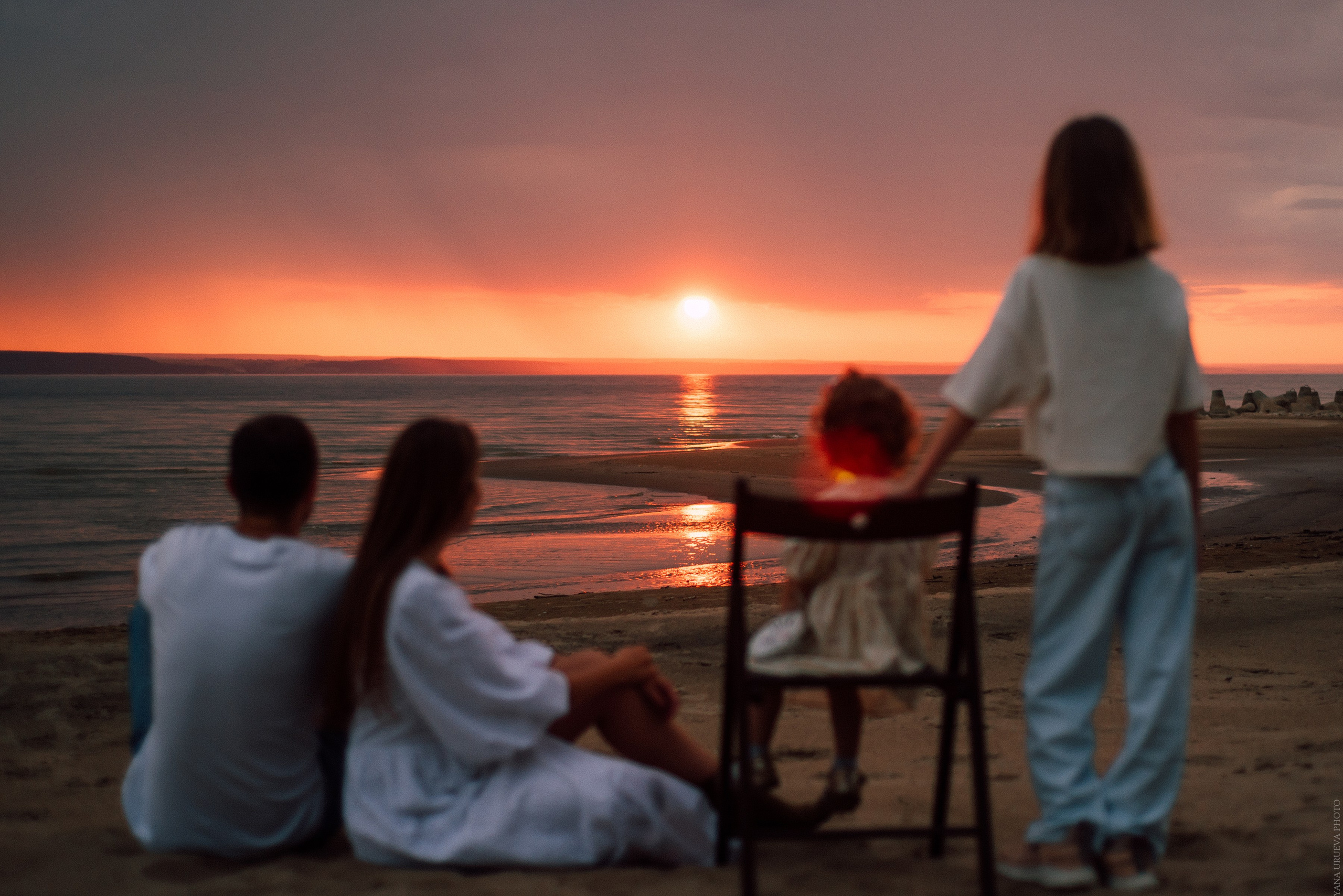 Семья смотрит на яркий закат