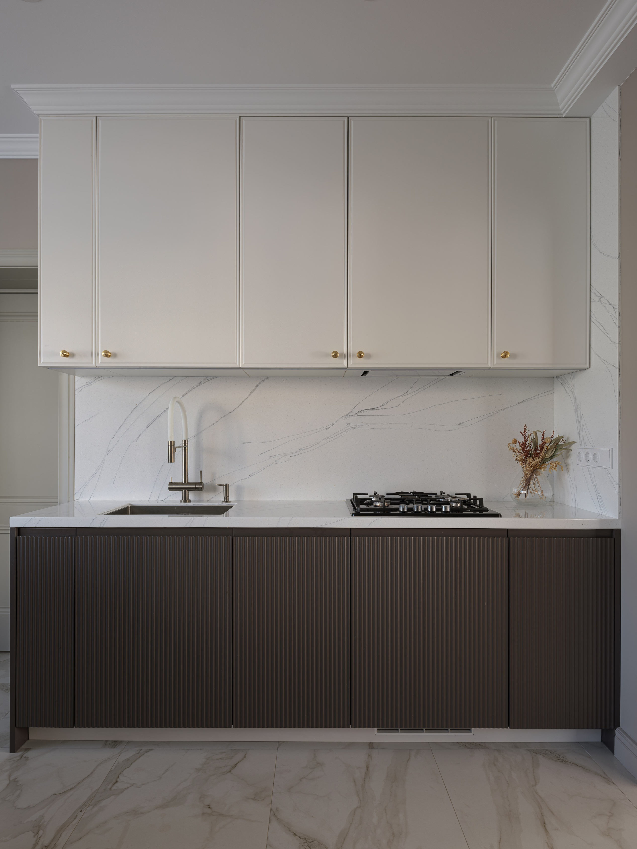 Стильный современный дизайн интерьера кухни с белыми верхними шкафами и темными фасадами внизу, мраморным фартуком и акцентной фурнитурой. Проект дизайнера Татьяны Диденко, фото Сергея Денисенко, стилизация Натальи Якушевой.