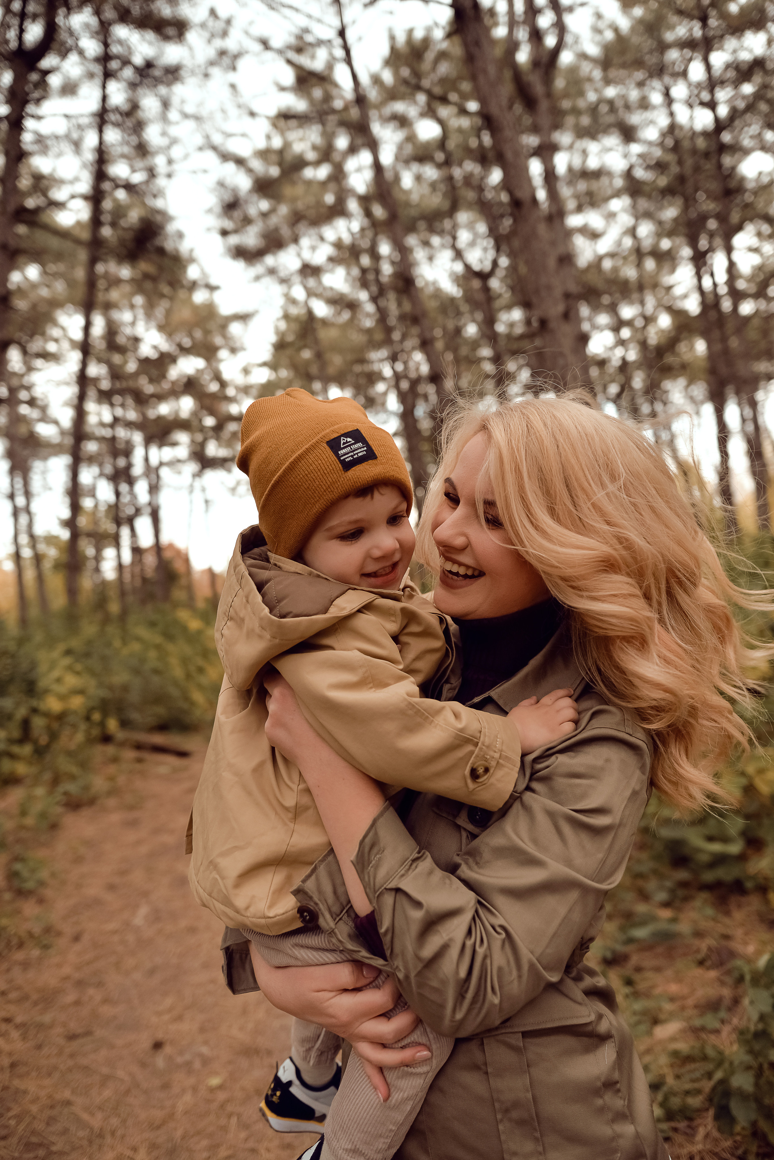 Мама играет в лесу с двухлетним сыном в шапочке