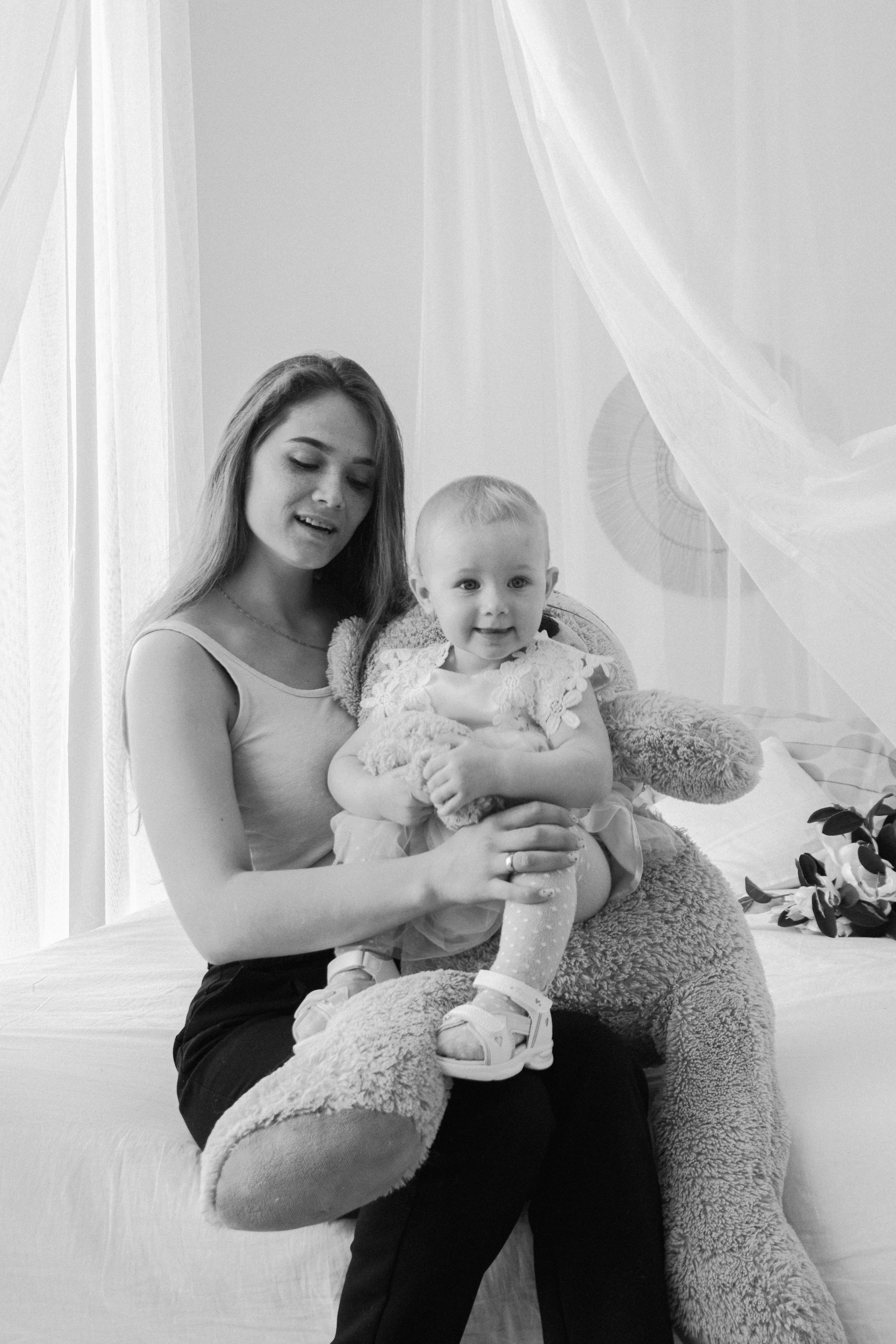 черно-белая фотография мамы с дочкой сидящих на кровати