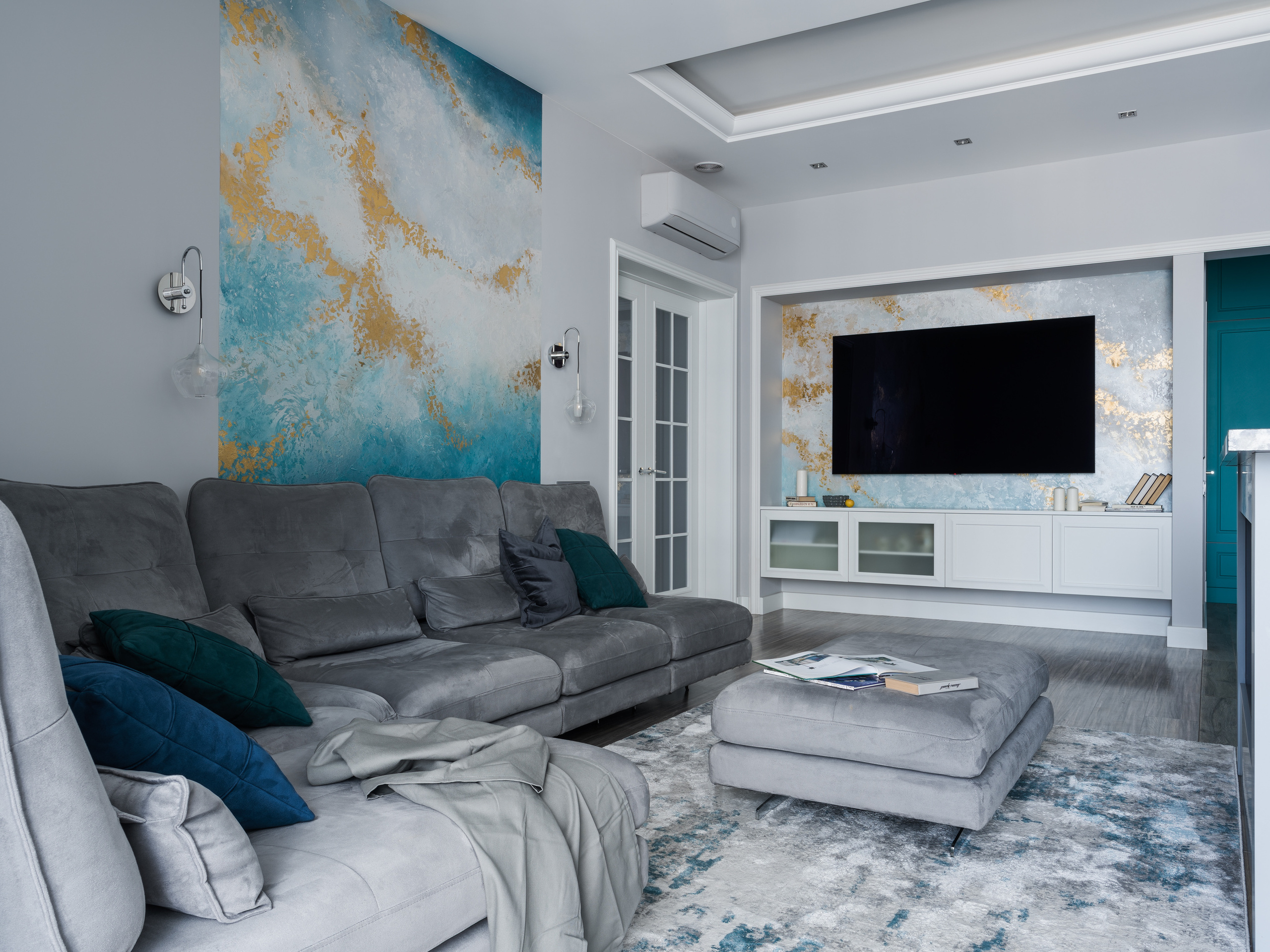 Современная гостиная в серых тонах с большим диваном, мягкими подушками и акцентной стеной с мраморным рисунком в золотых и бирюзовых оттенках, интерьер от дизайнера Евгении Княжевой, фото Сергея Денисенко.