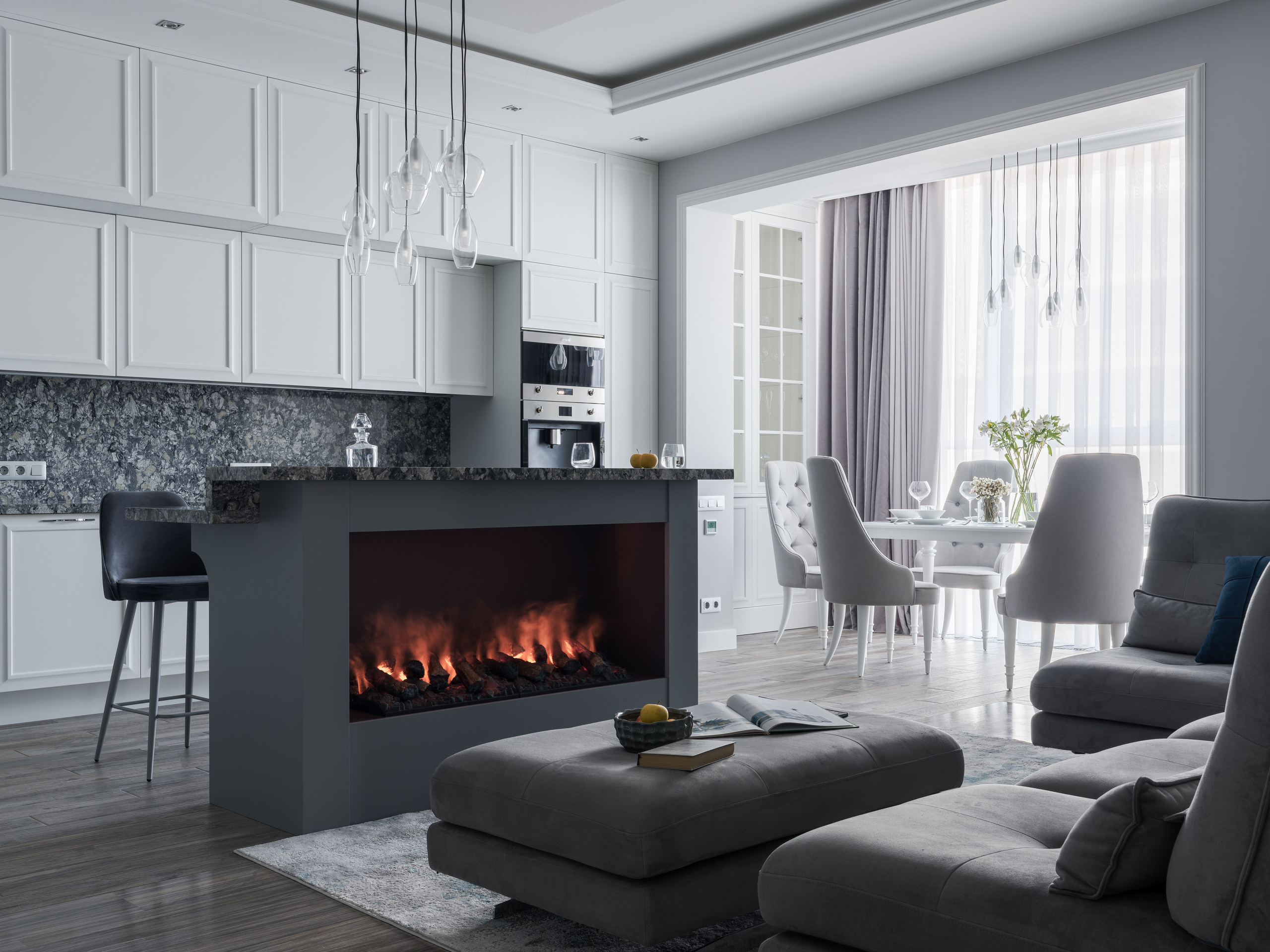 Уютная кухня-гостиная с камином, серым диваном, столовой зоной с мягкими креслами и белыми шкафами с каменной отделкой, авторский интерьер Евгении Княжевой, фото Сергея Денисенко.