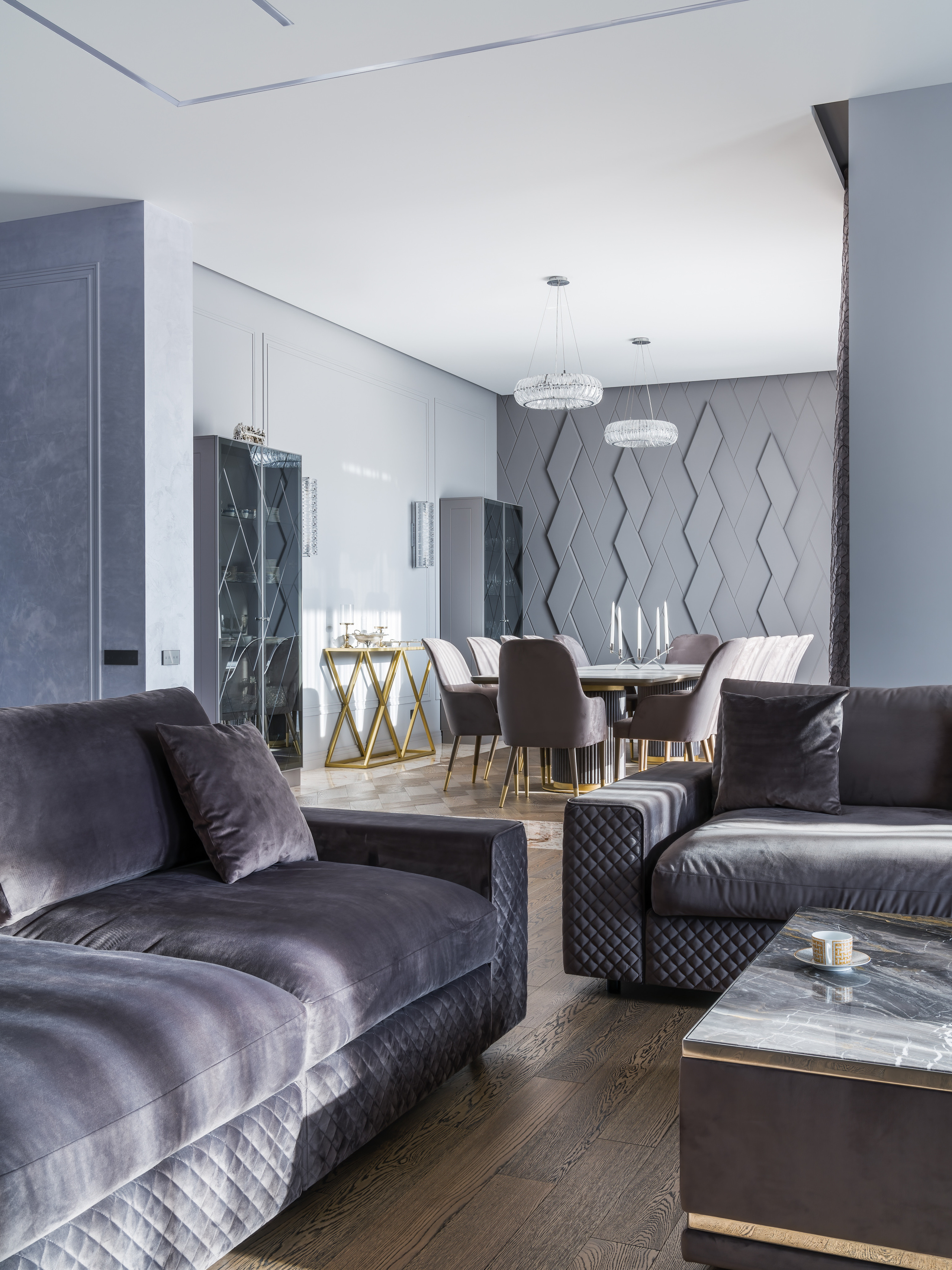 Вид из гостиной в столовую с серым диваном, мраморным столиком и бархатными креслами у дизайнерского стола; гармоничный современный интерьер от Анастасии Ковалевской, фото Сергея Денисенко.