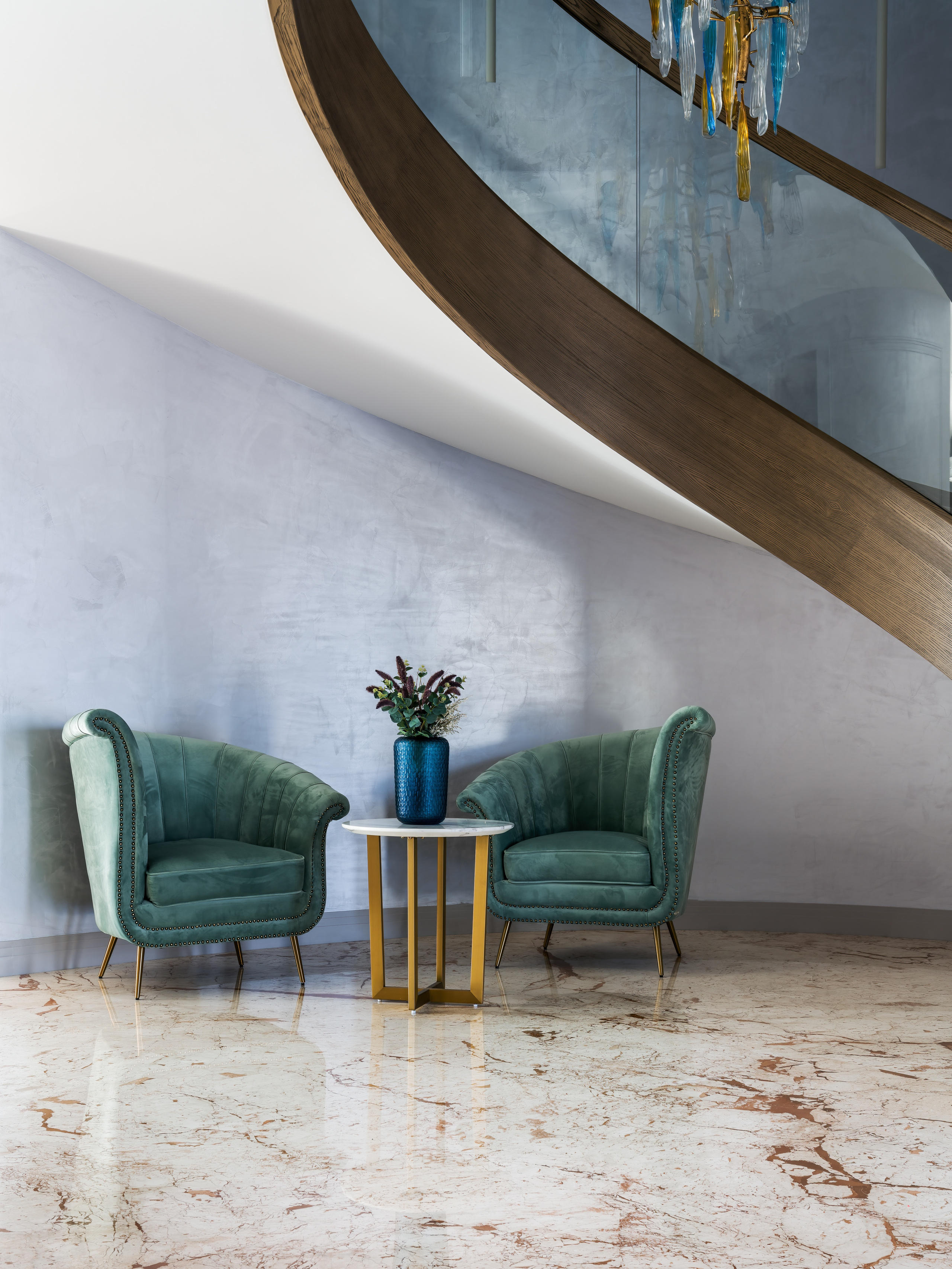 Зона отдыха у лестницы с двумя зелёными креслами на золотых ножках и круглым журнальным столиком в современном стиле, интерьерное решение Анастасии Ковалевской, художественная интерьерная фотография Сергея Денисенко.