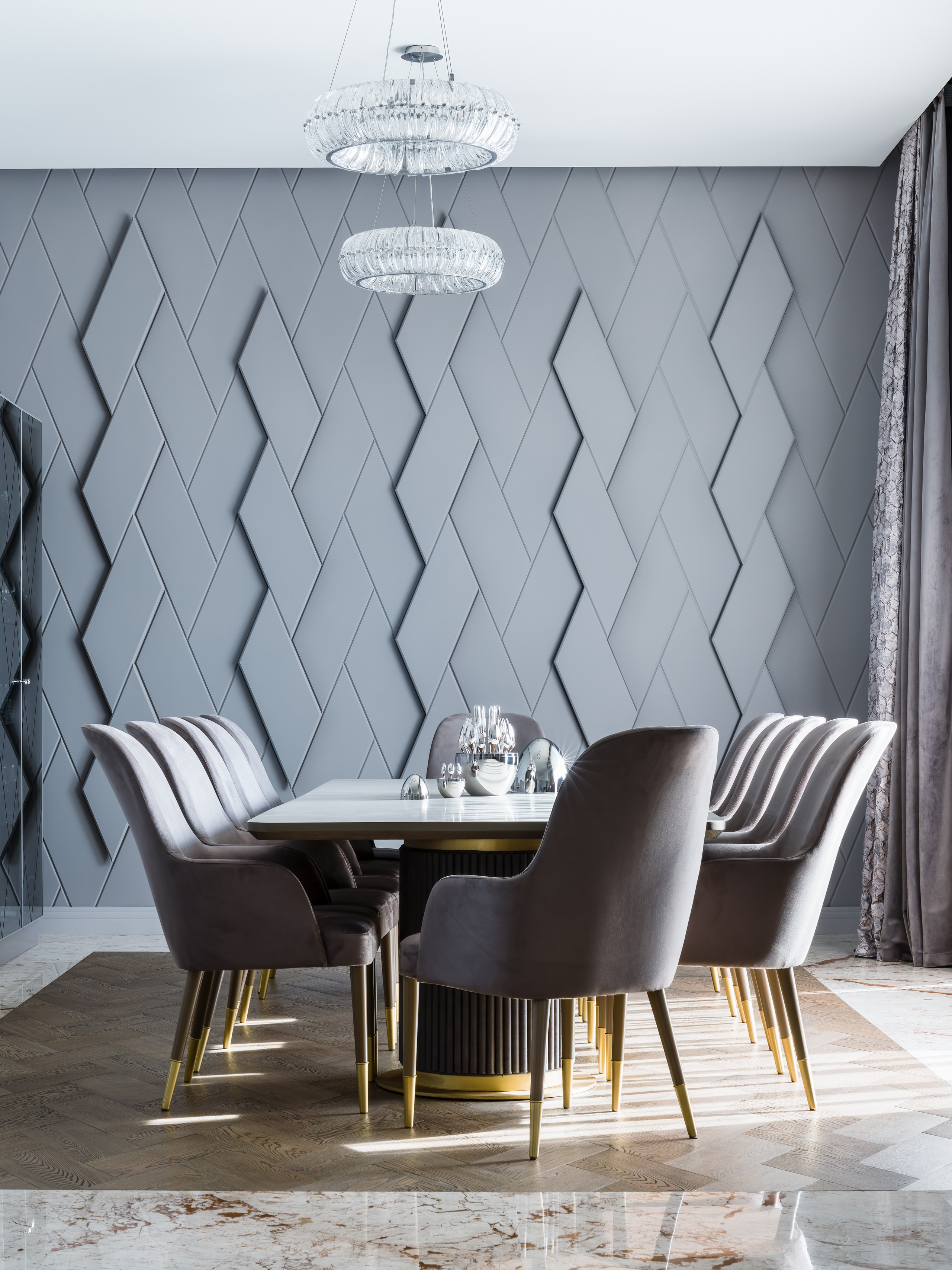 Современный интерьер столовой с дизайнерским обеденным столом, серыми креслами с золотыми акцентами и подвесными хрустальными люстрами; проект Анастасии Ковалевской, фотосъёмка Сергея Денисенко.