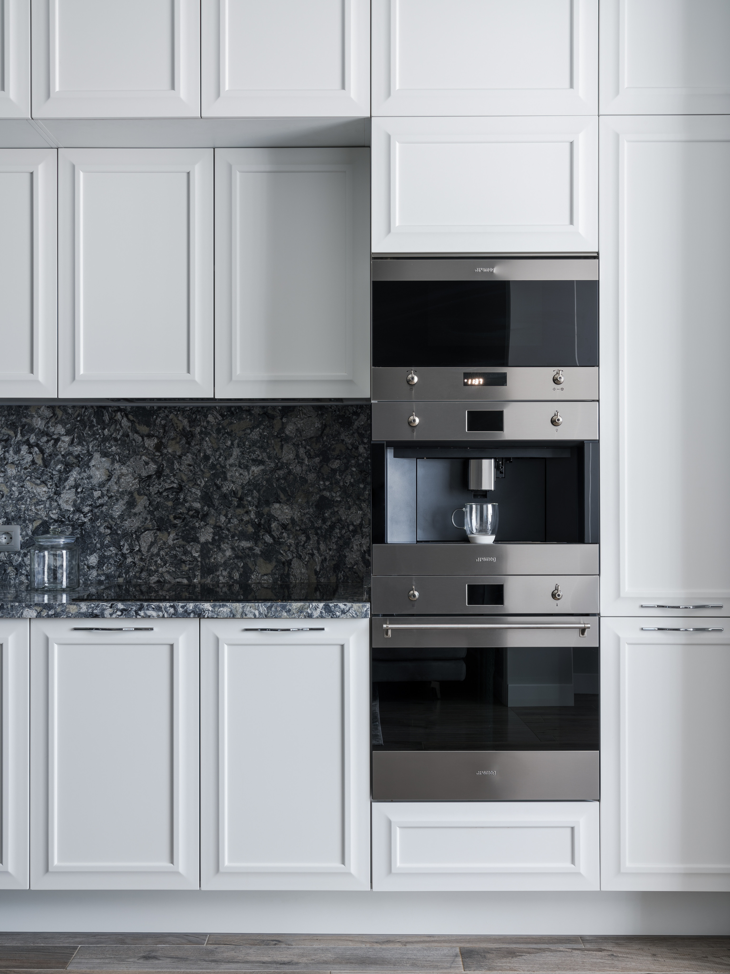 Стильная кухня с белыми фасадами, встроенной техникой Smeg и мраморным фартуком в серых оттенках, современный интерьер от дизайнера Евгении Княжевой, профессиональная интерьерная фотография Сергея Денисенко.