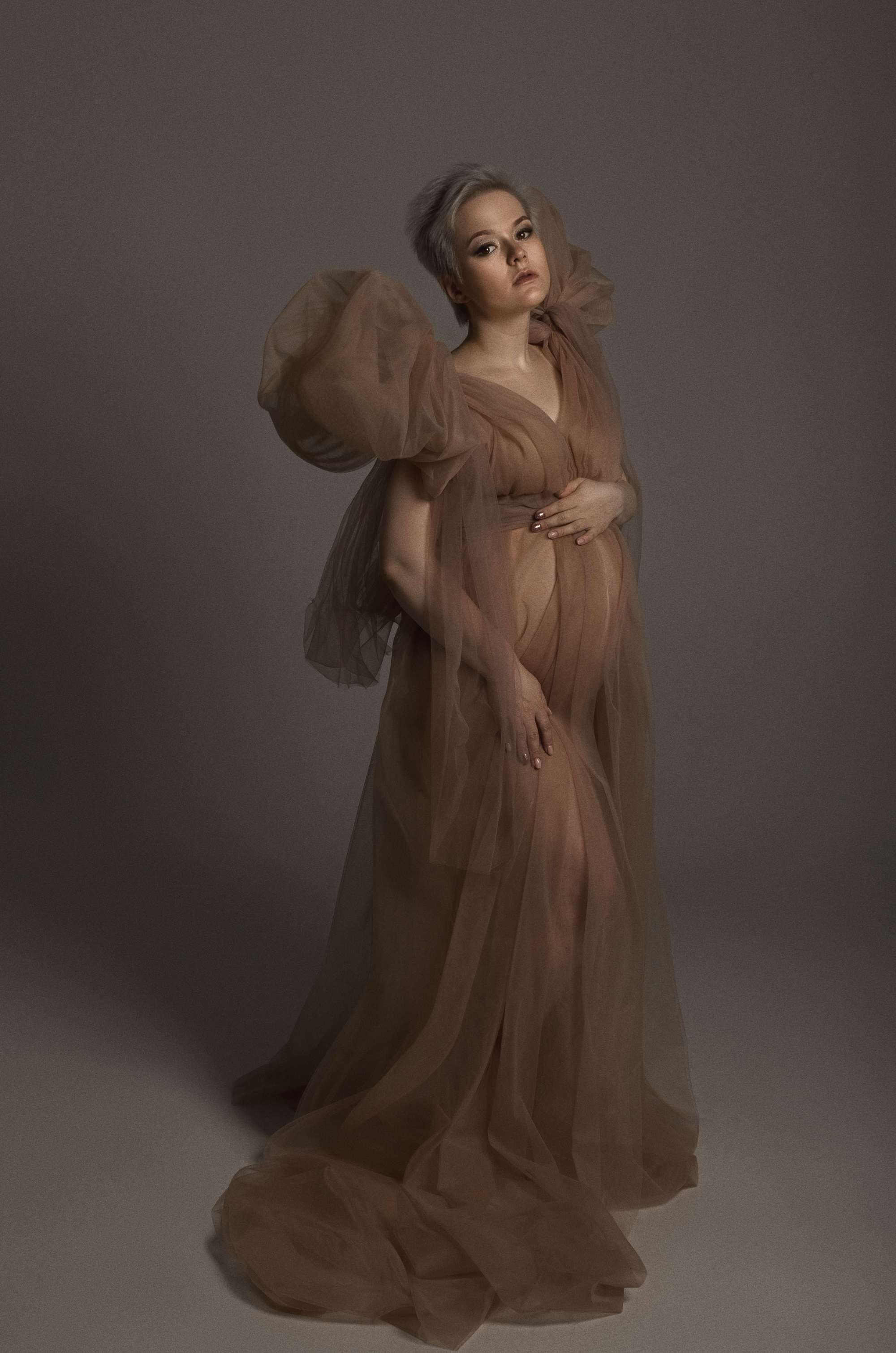 фотосессия беременной в фотостудии на темном фоне в красивом разлетающемся платье, фотография беременности, фотосессия беременных, портрет беременной