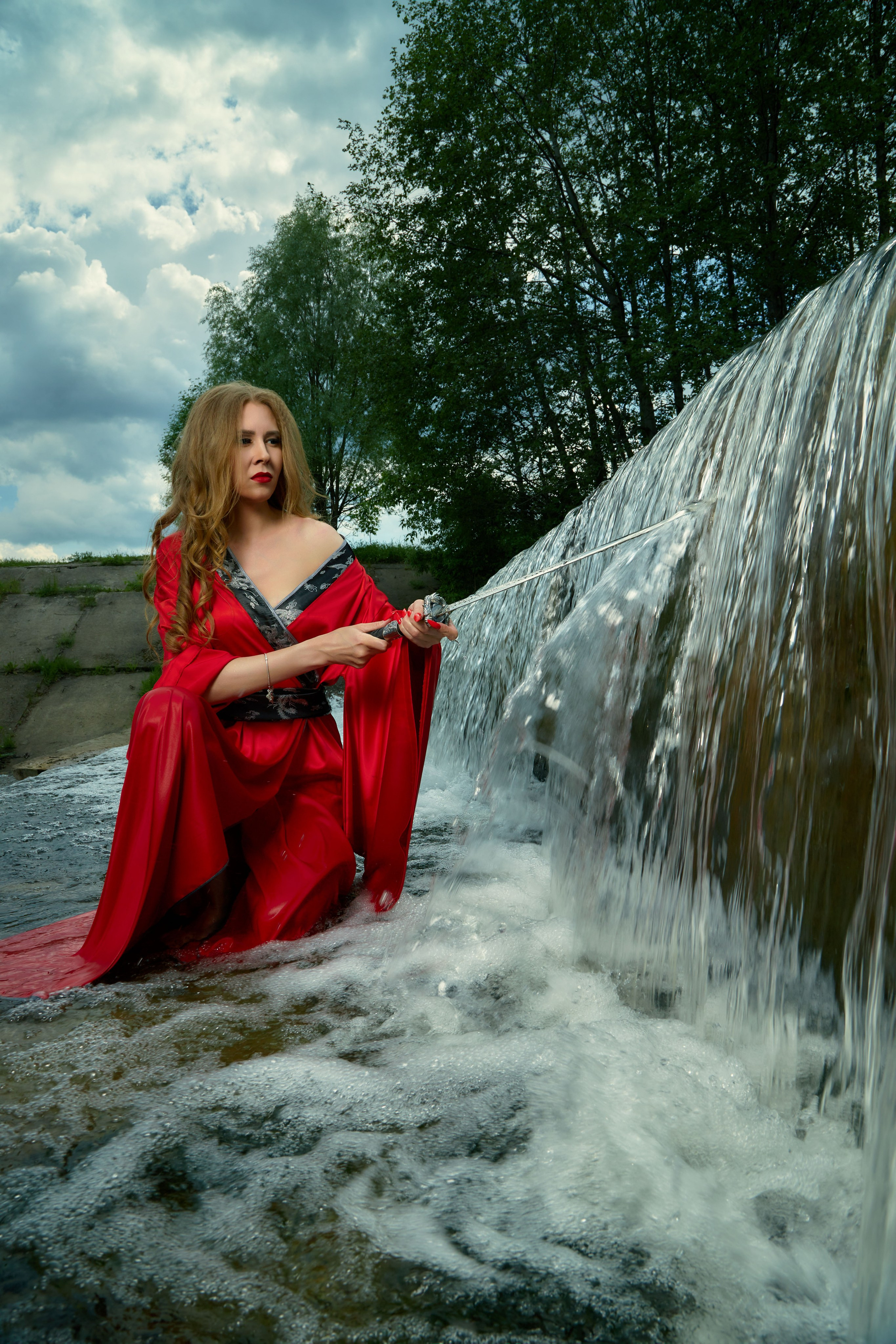Девушка в красном кимоно на фоне водопада в торхлово