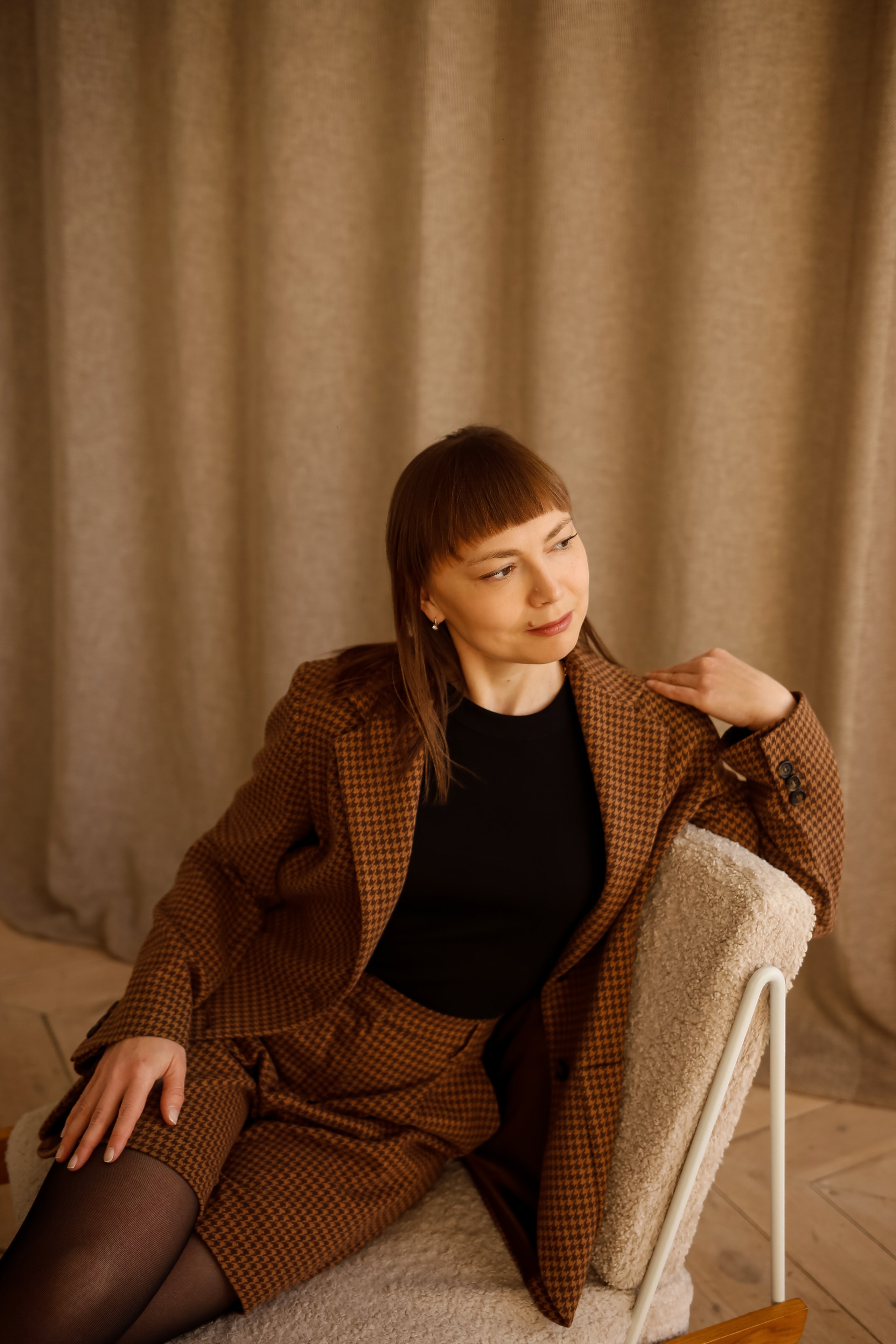 девушка расслаблено сидит на кресле позирует