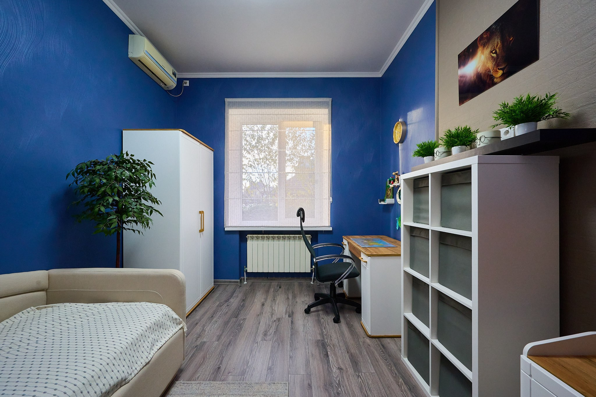 синие обои белый шкаф белый диван  рабочий стол кресло 