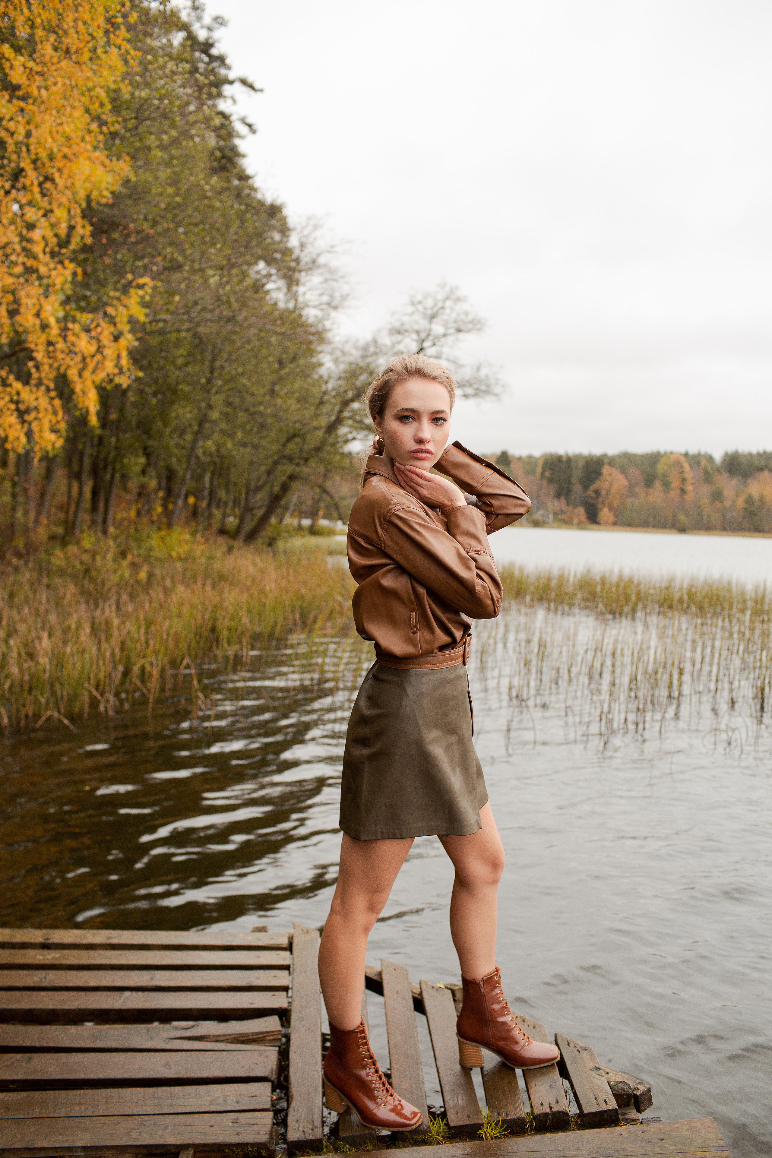 девушка в кожаной одежде на фоне озера осенью