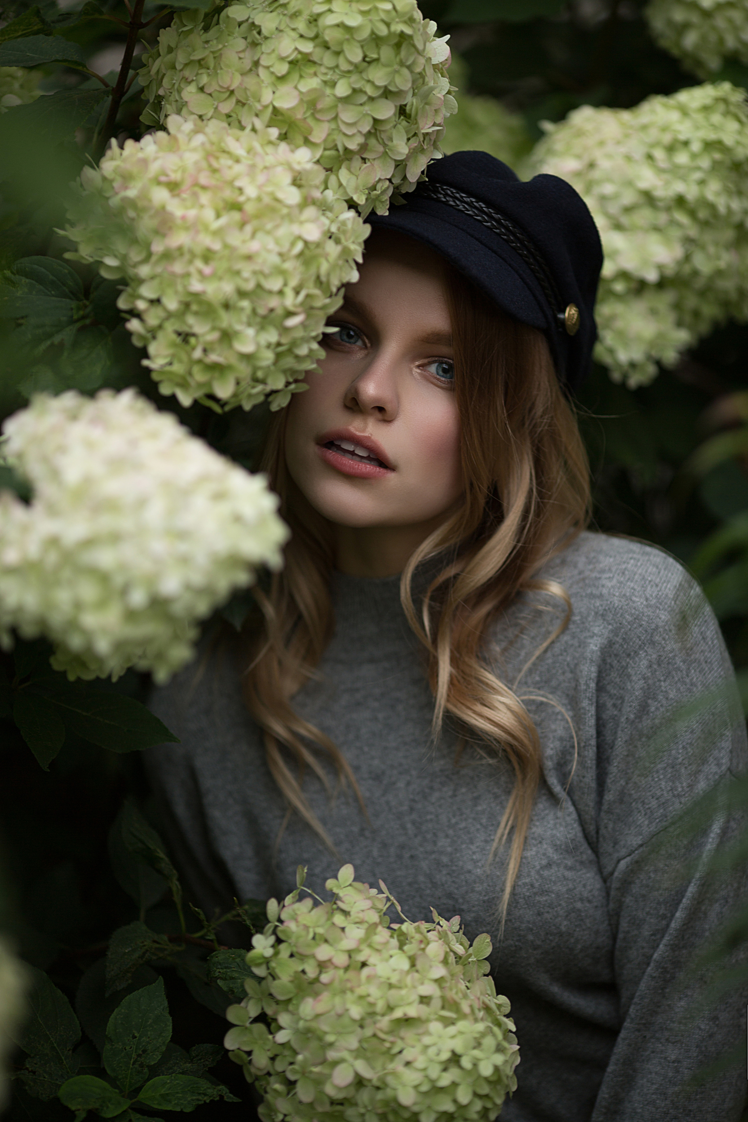 портрет девушки в кепи на фоне белых гортензий 