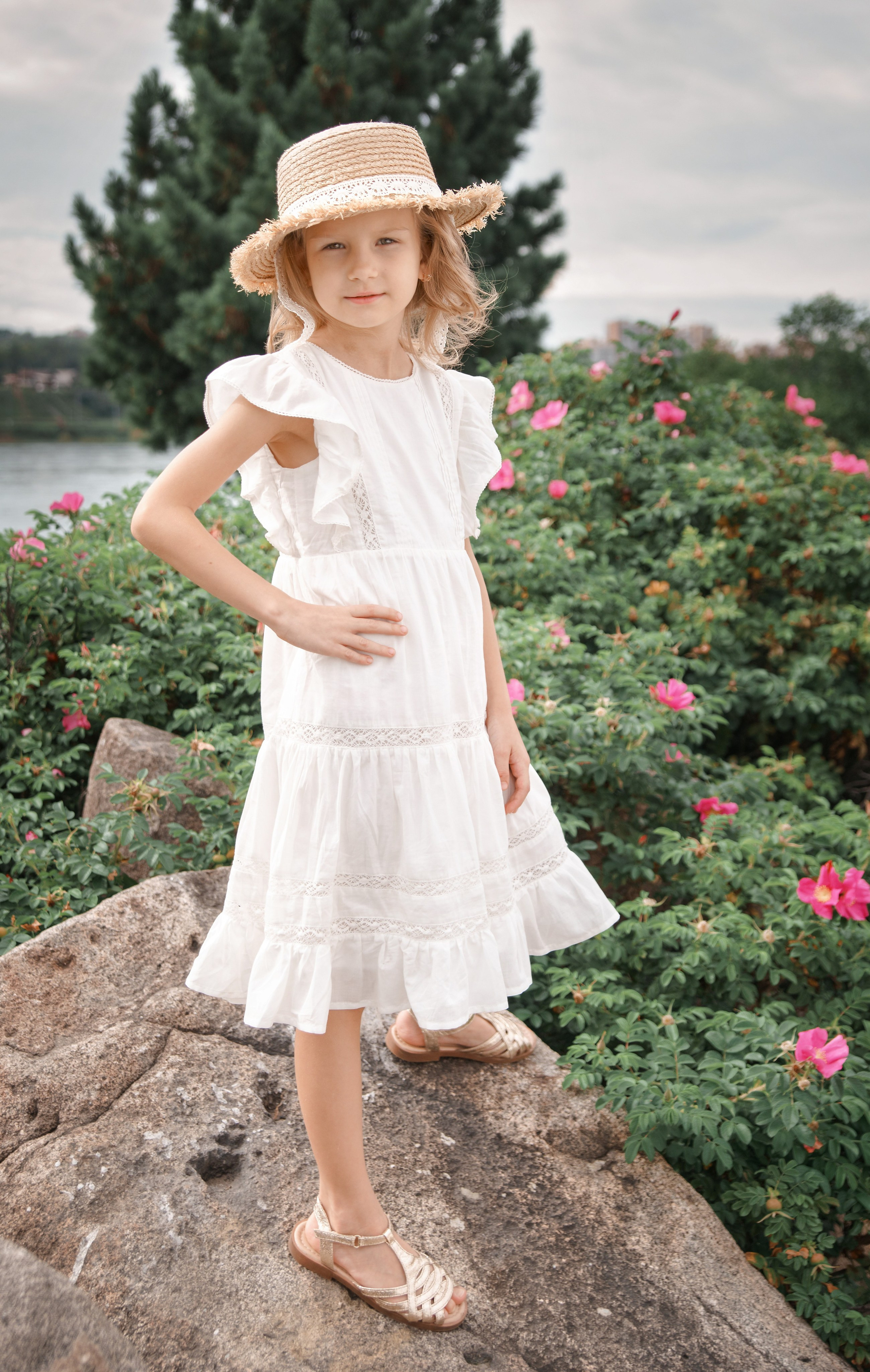 Детская фотосессия летом - девочка стоя на камне в шляпе