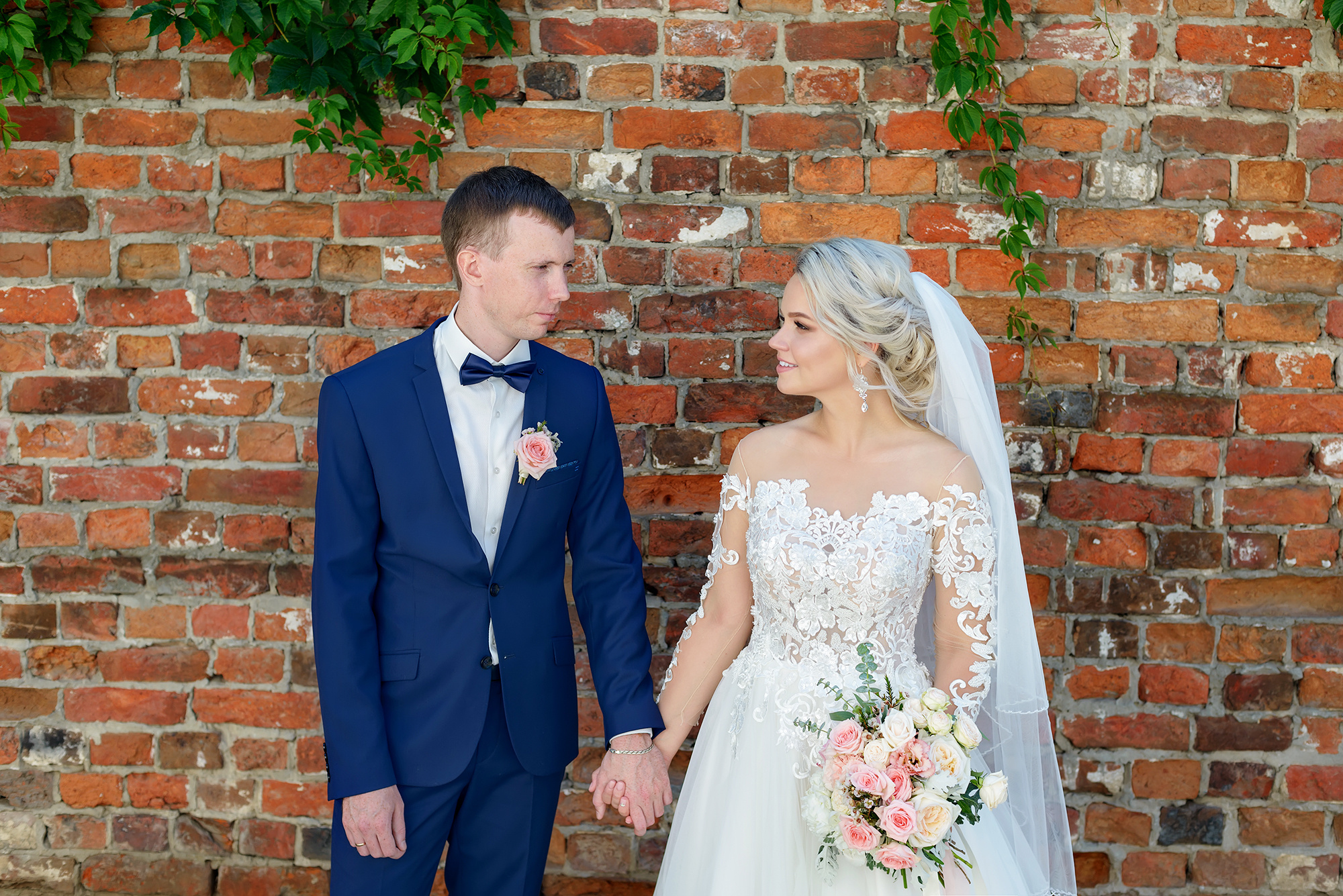 Жених и невеста на фоне кирпичной стены