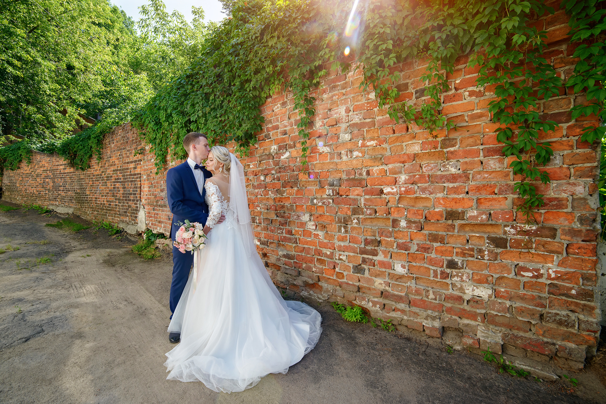 Жених и невеста на фоне кирпичной стены