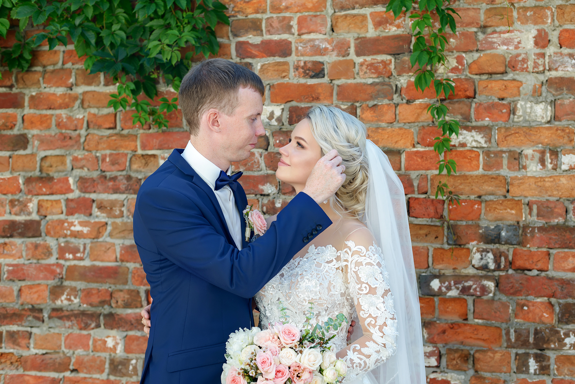 Жених и невеста на фоне кирпичной стены