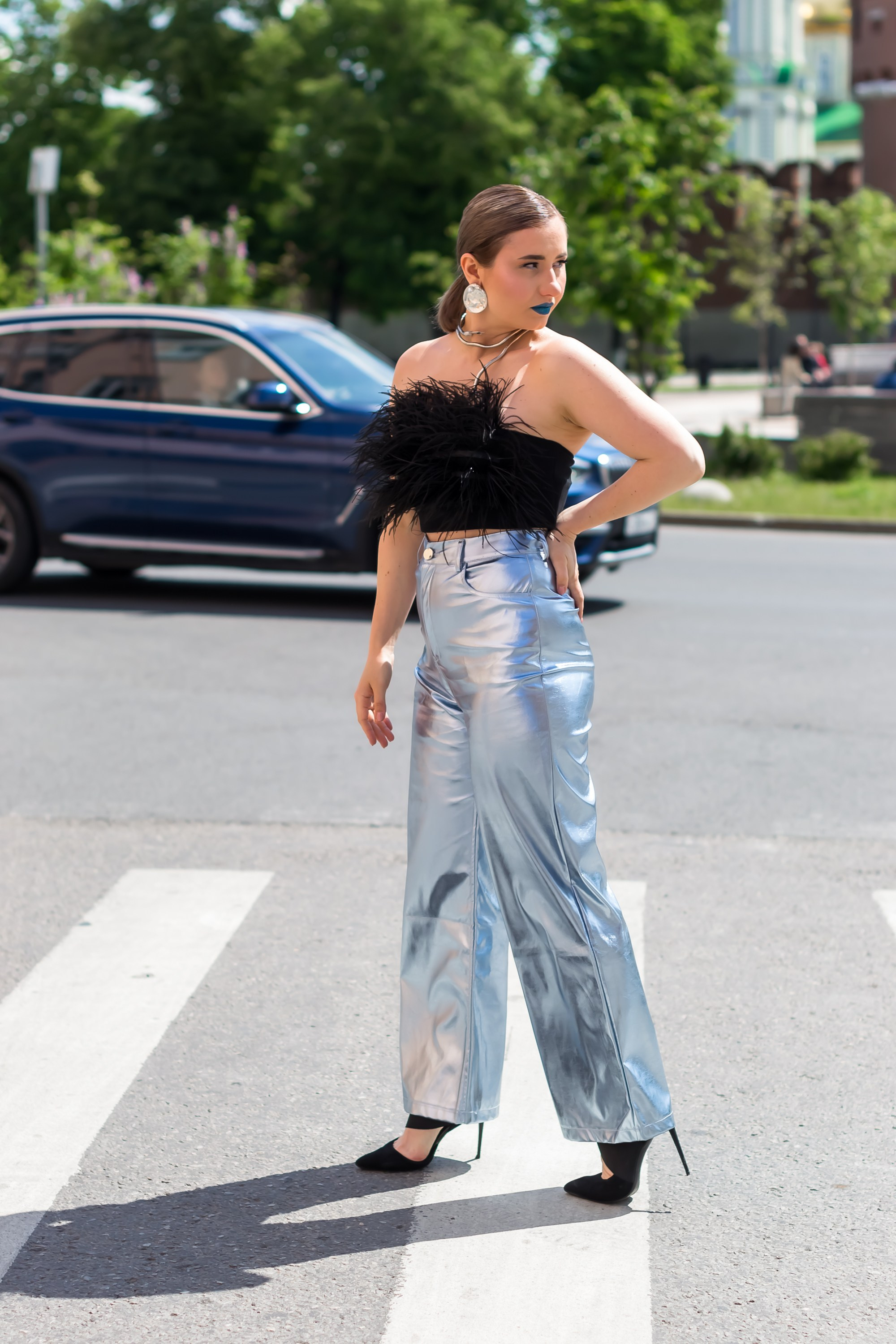 На фотографии девушка стоит по улице.