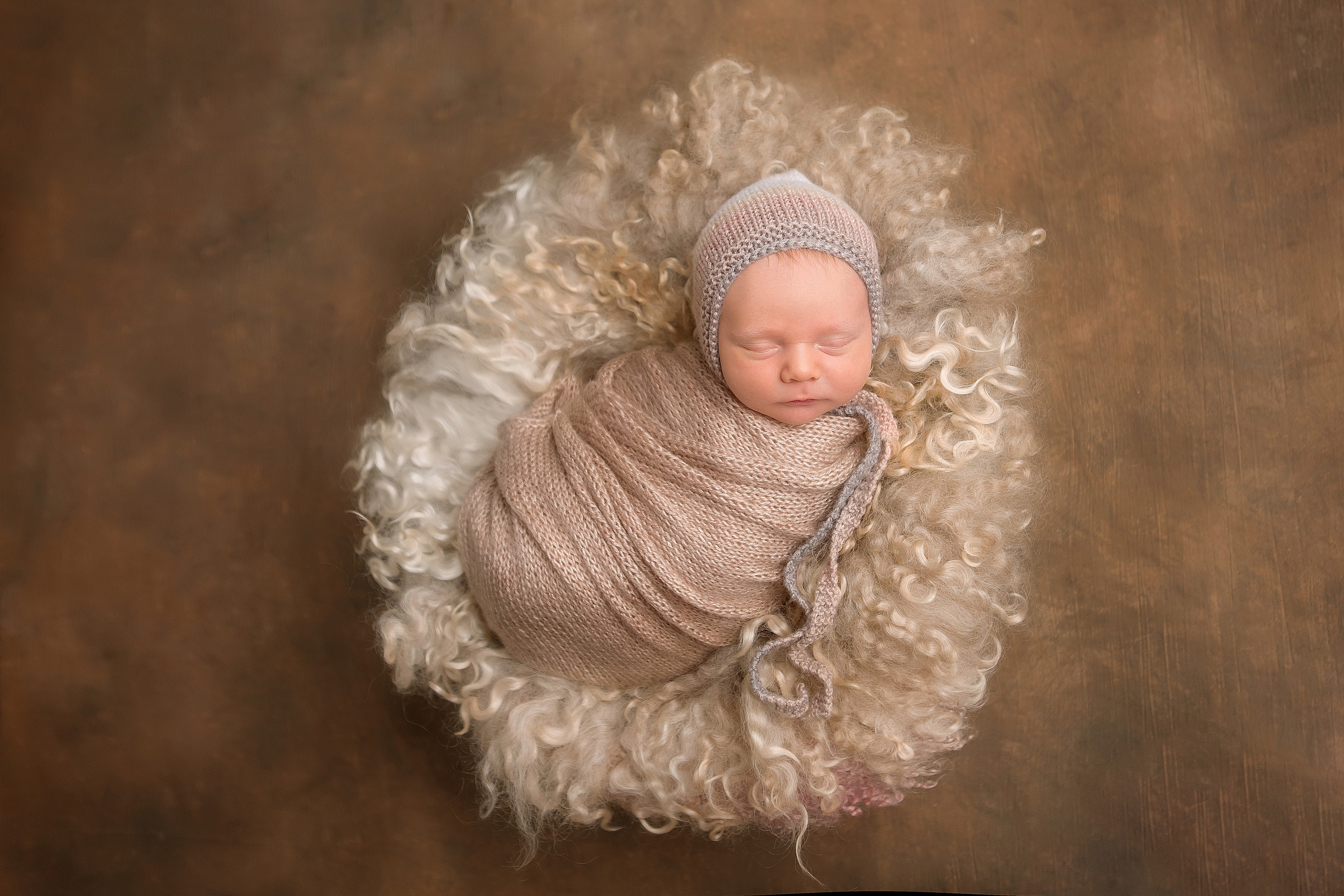 новорожденный малыш спит в пушистом детском кресле