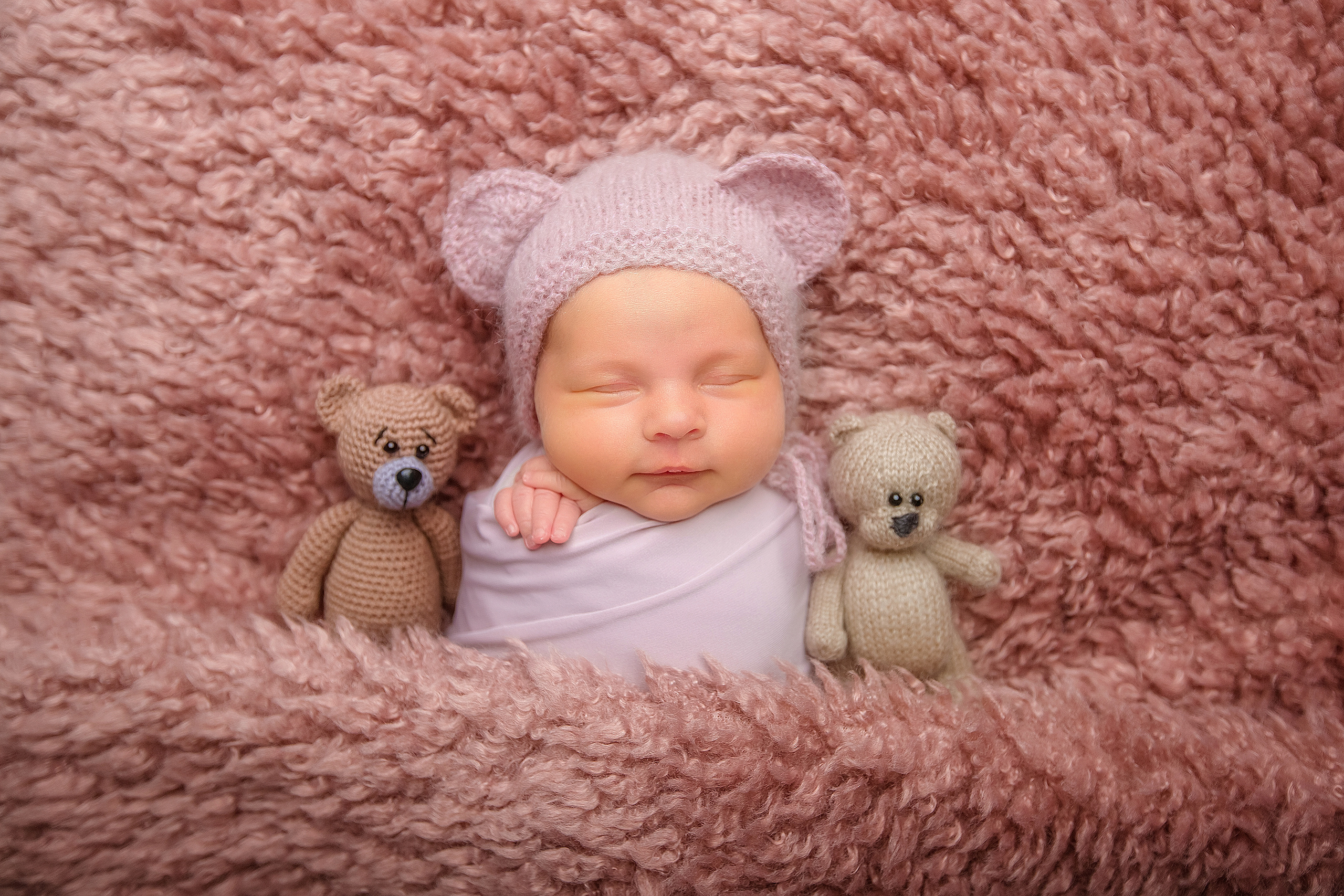 новорожденный малыш в костюме медвежонка с мягкими игрушками