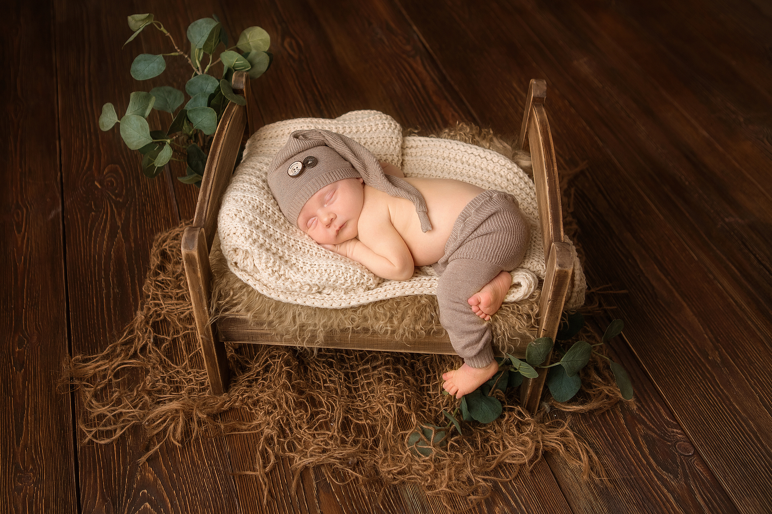 новорожденный малыш в шапочке зайчика спит в детской кровати