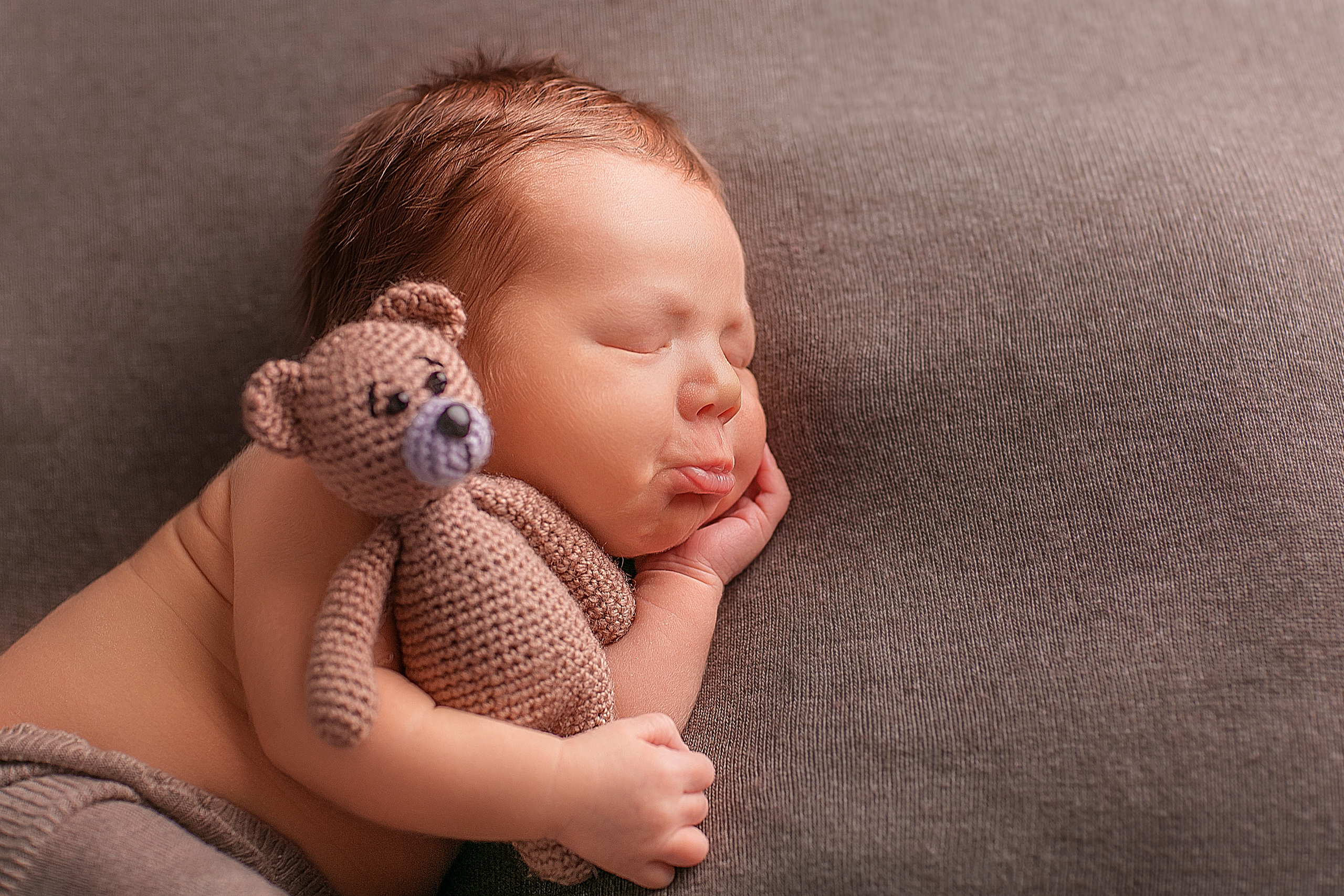 спящий новорожденный малыш с мягкой игрушкой медвежонка 