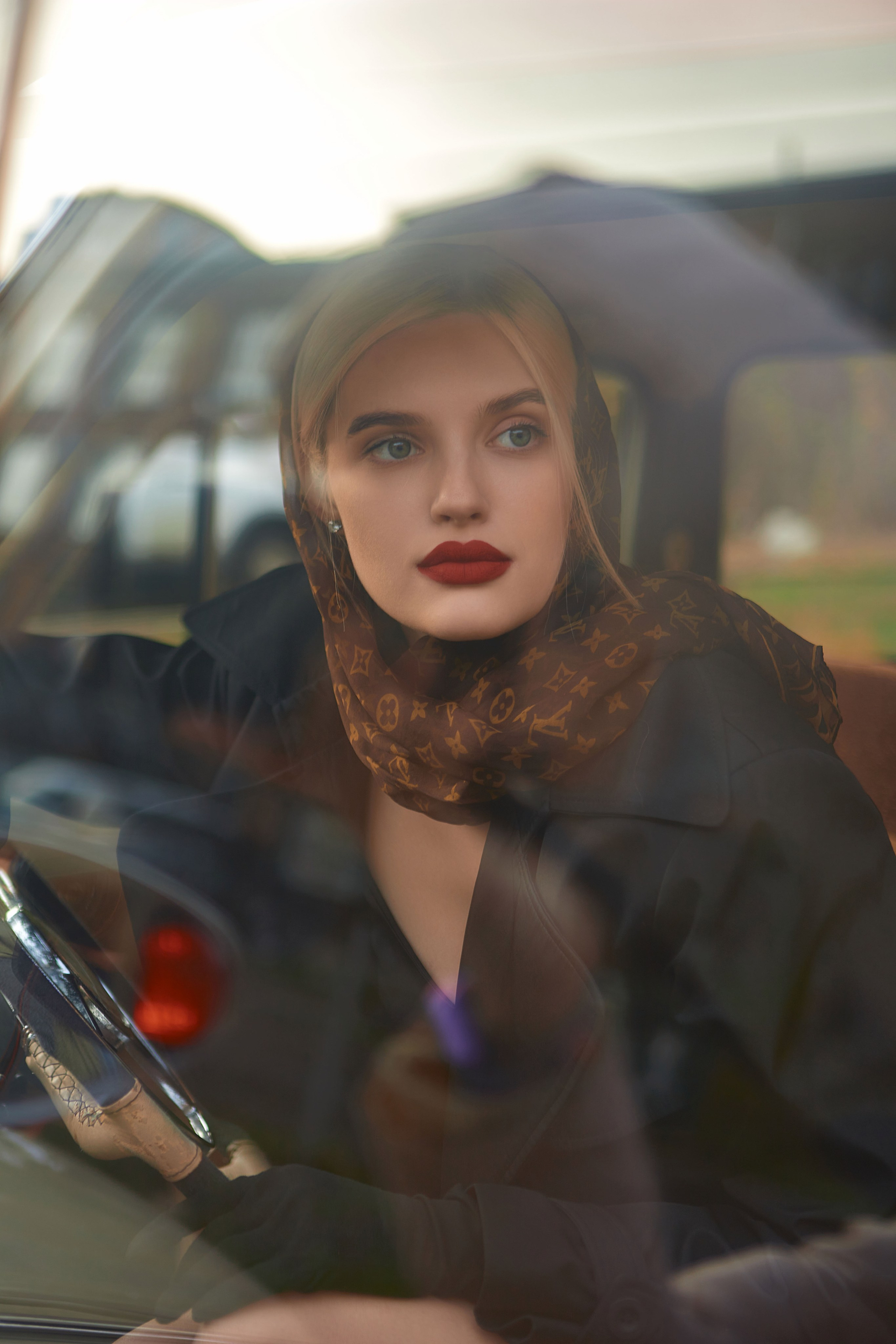 Портрет девушки в ретро стиле через лобовое стекло автомобиля