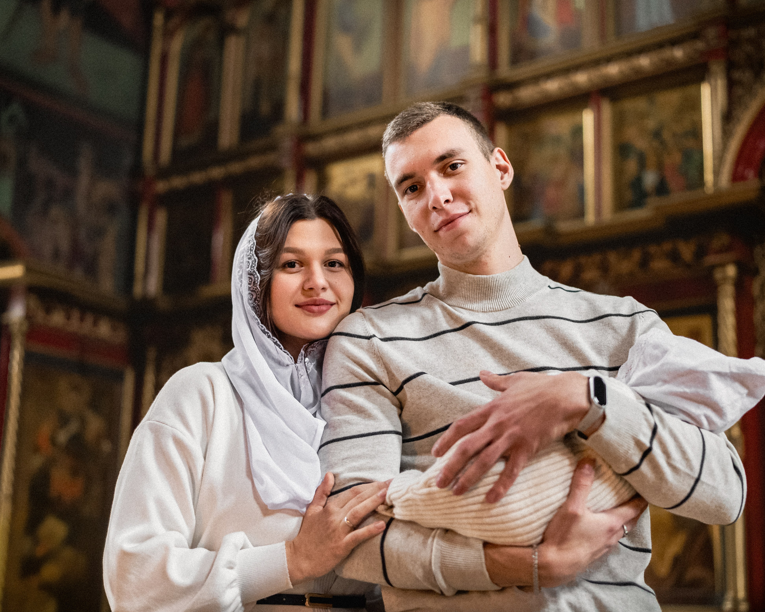 Родители держат ребенка после крестин в Зеленограде