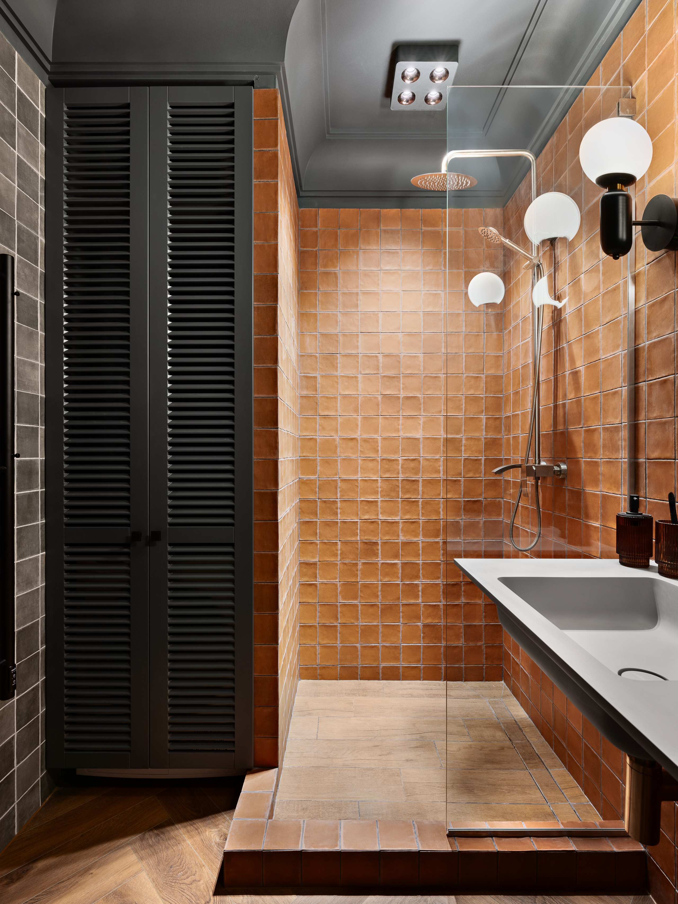 Душевая зона в ванной комнате с акцентной терракотовой плиткой, встроенным смесителем и геометрией современного стиля; гармоничный интерьер, созданный дизайнером Антоном Логиновым, стилизованный Алёной Мощенской, фотограф Сергей Денисенко.
