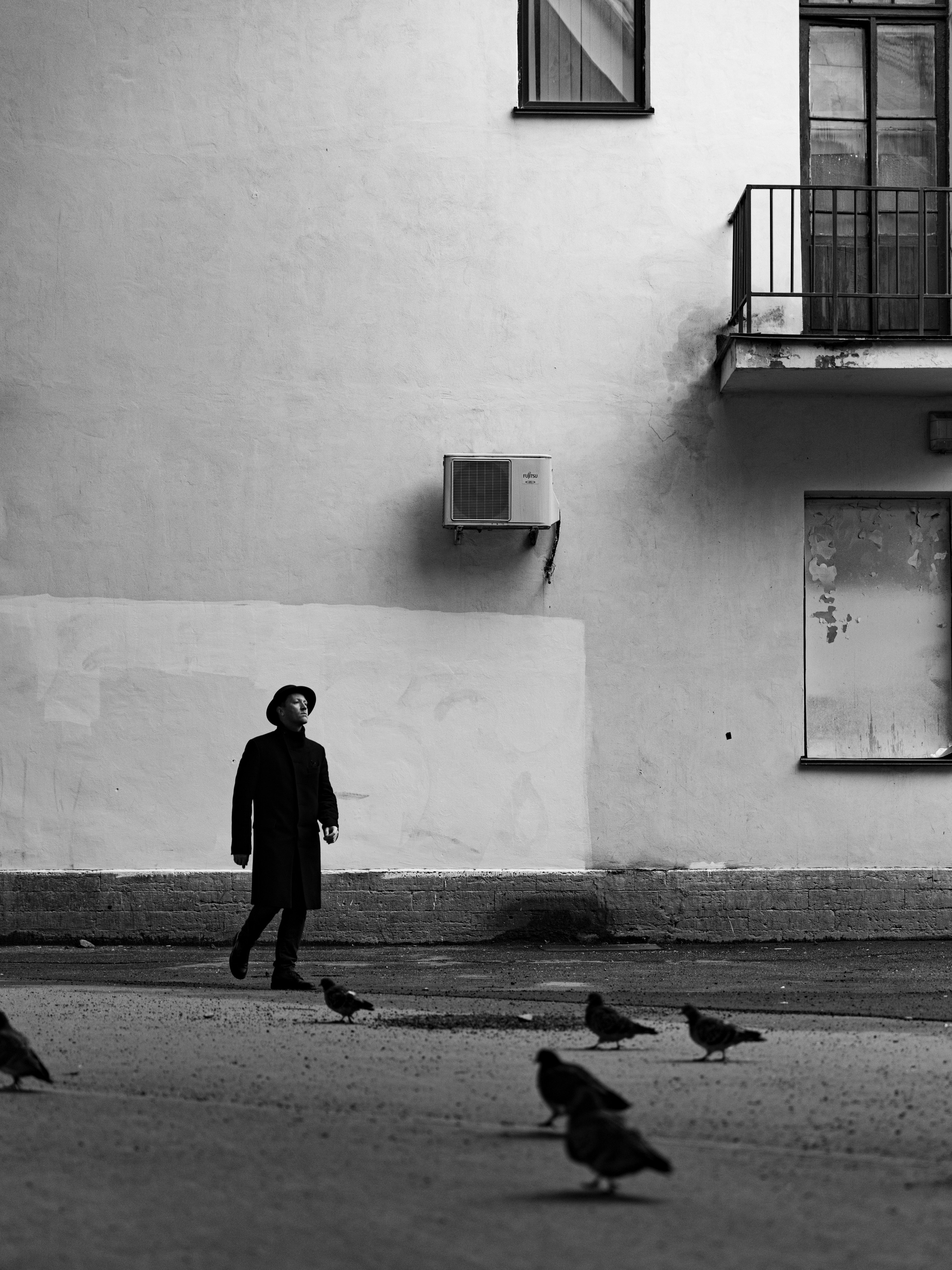 Черно-белое фото мужчины в пальто на улице