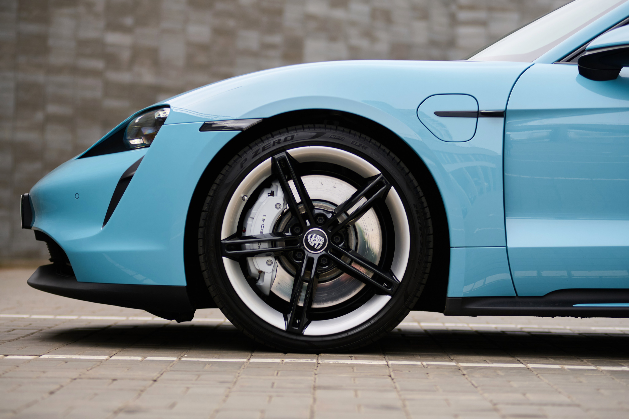Переднее колесо и боковая часть голубого Porsche Taycan 4S