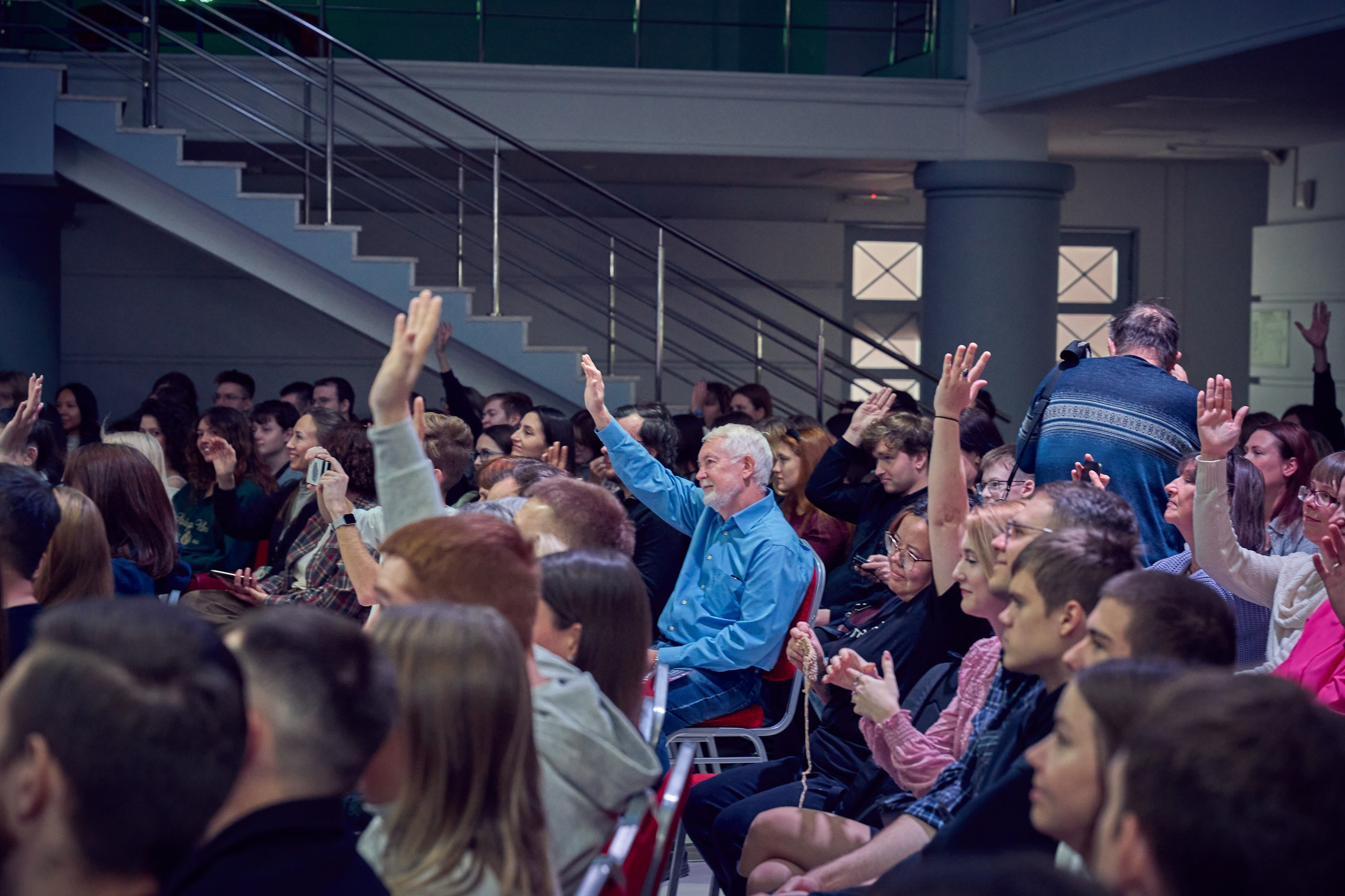 люди тянут руки чтобы задать вопрос